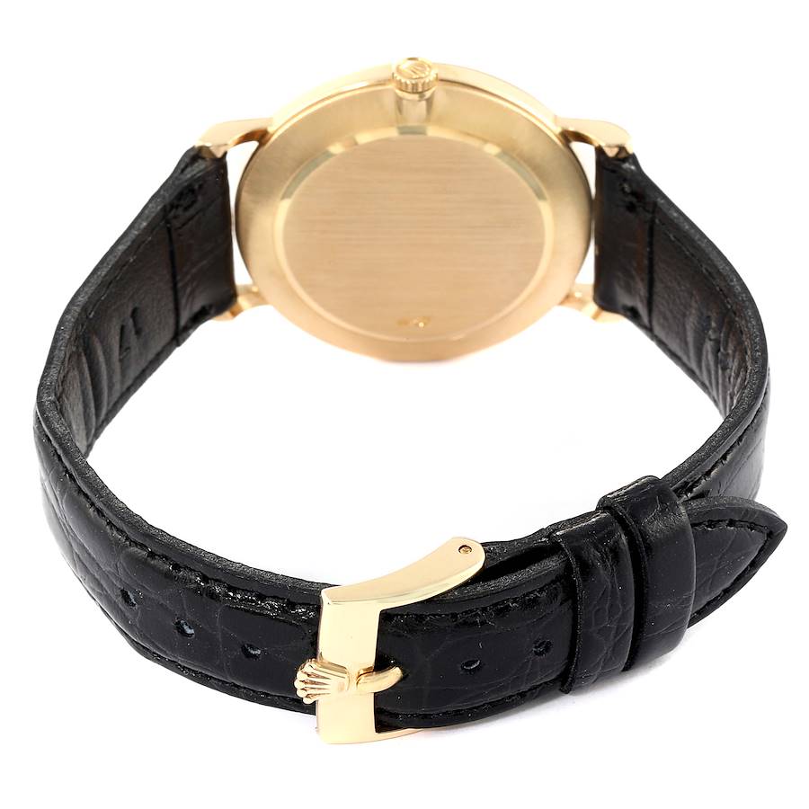 The image shows the backside of a Rolex Cellini 5112 Men's Yellow Gold Mother of Pearl Dial 5112 Men's Yellow Gold Mother of Pearl Dial watch with a gold case and black leather strap, highlighting the buckle and crown.