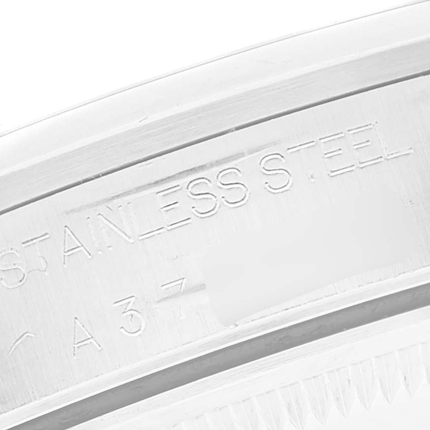The image shows a close-up of the side engraving on a Date model Rolex watch, indicating "Stainless Steel."