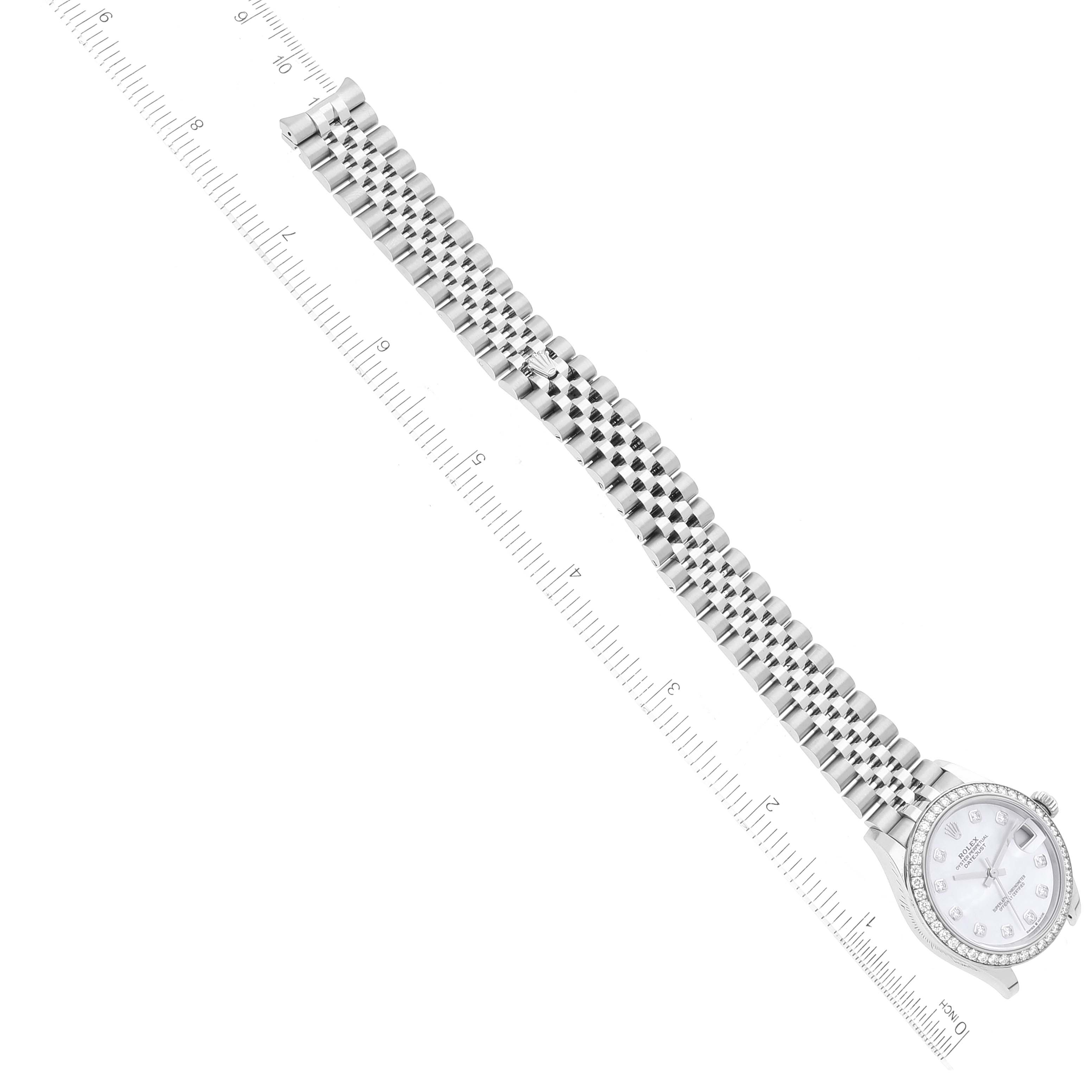 The image shows a top-down view of a Mid-Size Rolex watch, including its face and metal bracelet alongside a ruler.