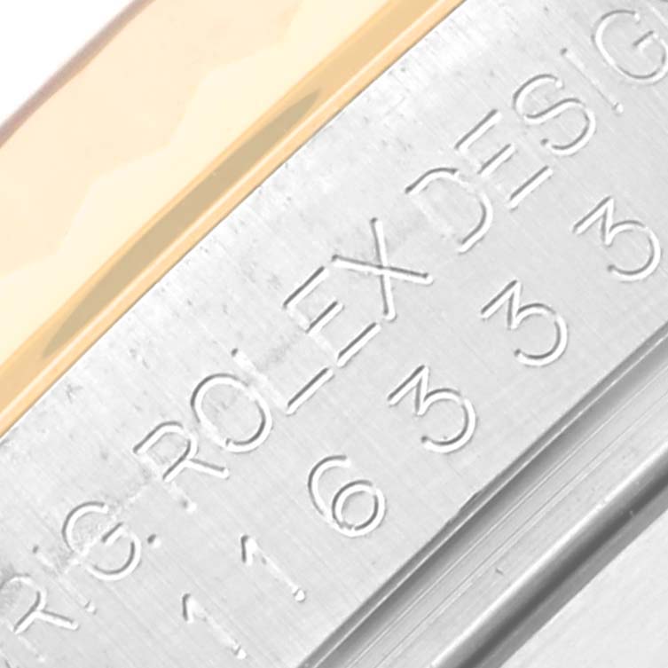 The image shows a close-up of the engraved bezel of a Rolex Datejust 41 116333 Men's Steel and Gold (two tone) Silver Dial 116333 Men's Steel and Gold (two tone) Silver Dial watch, highlighting part of the serial number and brand name.