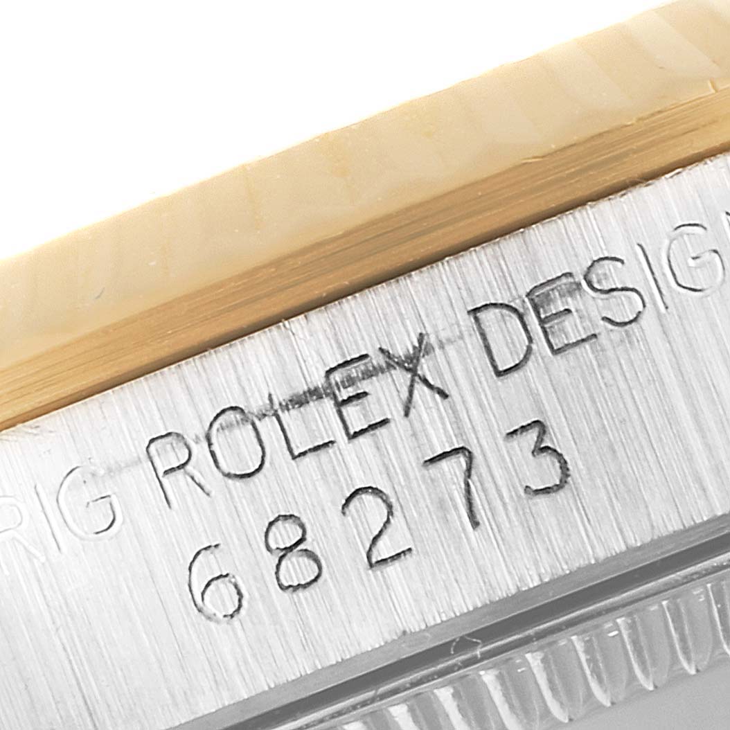 The close-up image shows the side of a Rolex Mid-Size 68273 Women
s Steel and Gold (two tone) Champagne Dial 68273 Women
s Steel and Gold (two tone) Champagne Dial model, highlighting the model number 68273 and "Rolex Design" engraving.