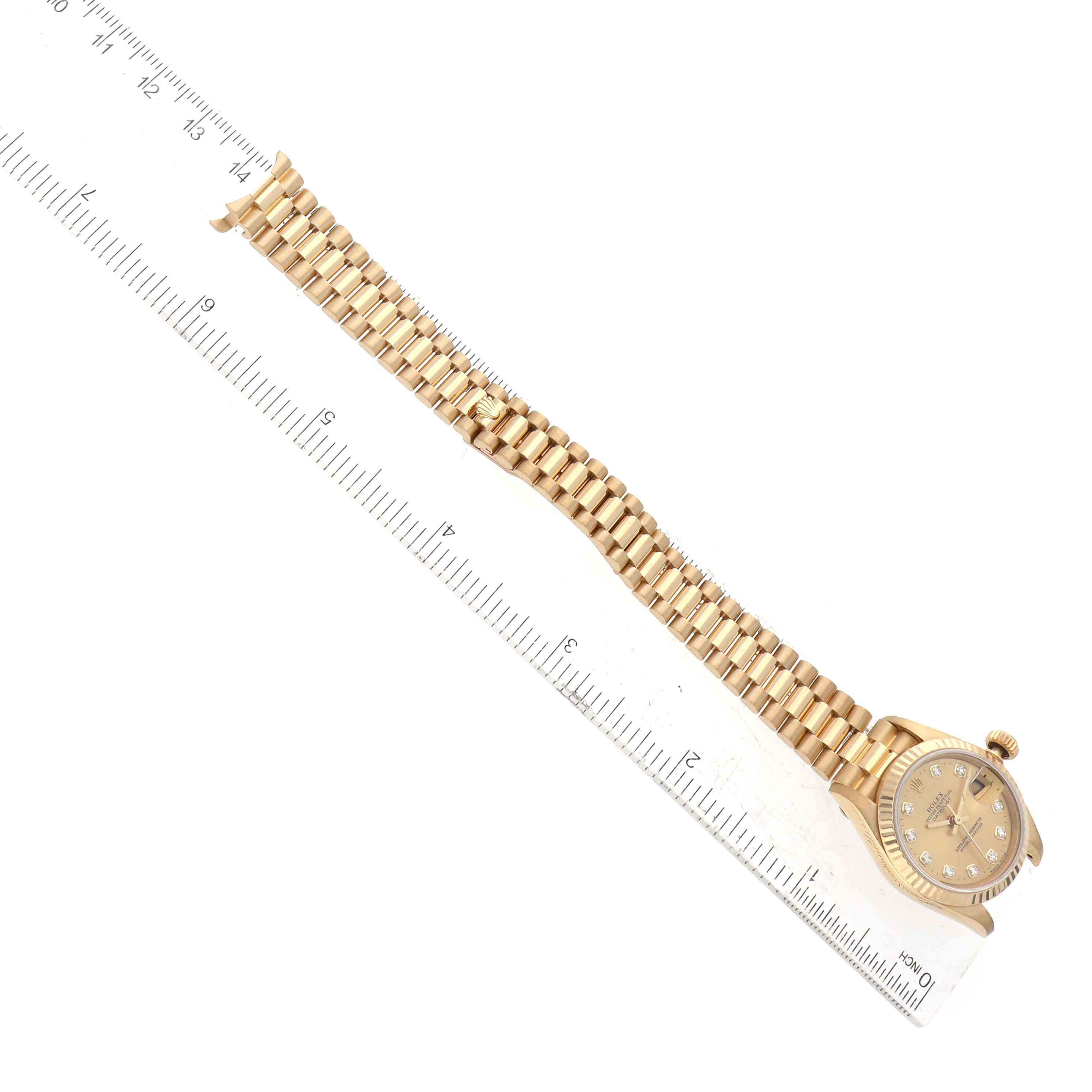 The image shows a Rolex President 69178 Women's Yellow Gold Champagne Dial 69178 Women's Yellow Gold Champagne Dial model watch laid flat alongside a ruler, displaying both the watch face and bracelet.