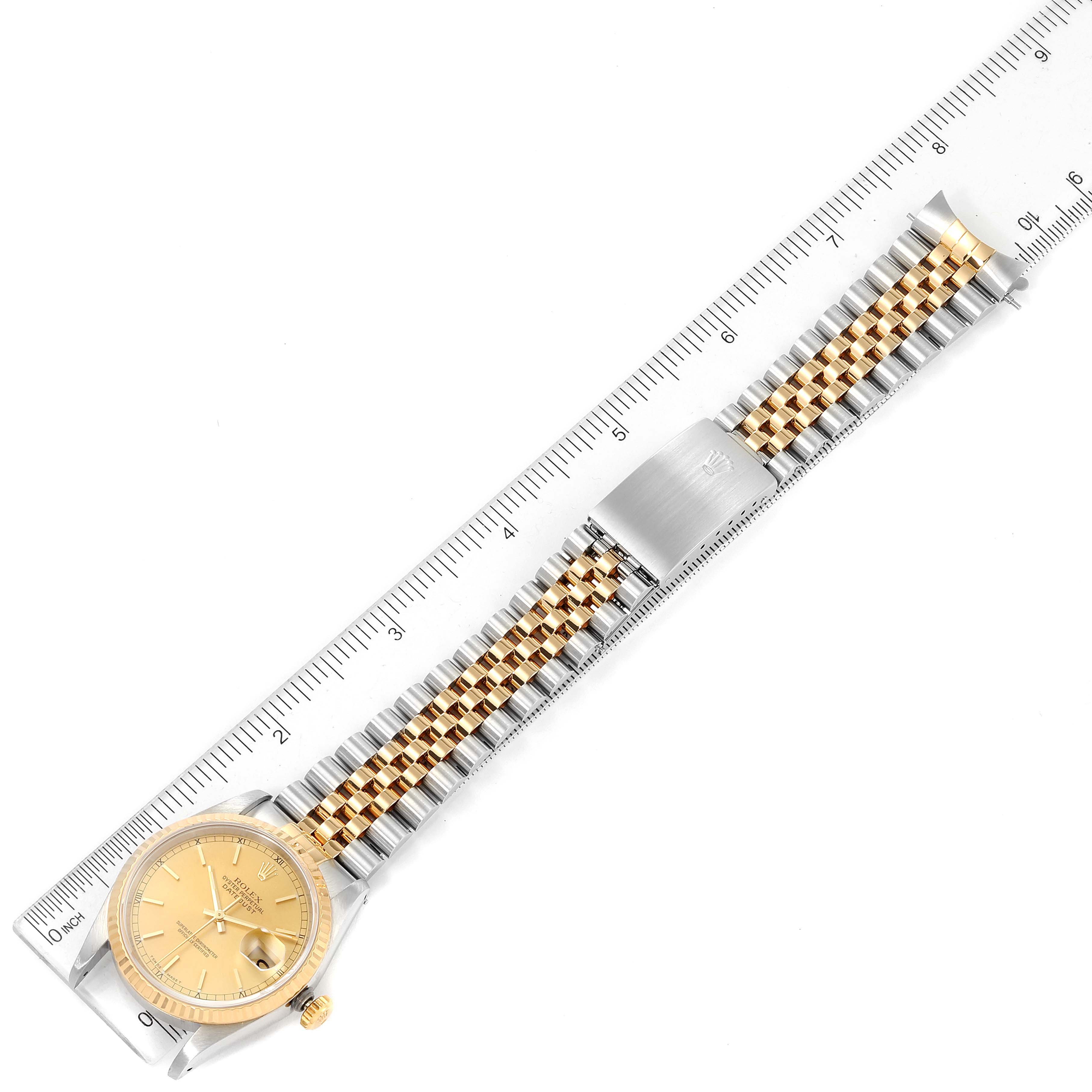 This Rolex Datejust 16233 Men's Steel and Gold (two tone) Champagne Dial 16233 Men's Steel and Gold (two tone) Champagne Dial watch is shown from a top-down view and includes the dial, bezel, bracelet, and clasp along a ruler for scale.