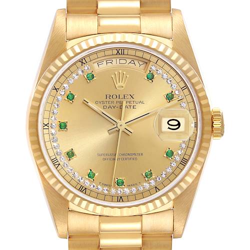 The image shows a close-up of the dial and bracelet of a gold Rolex President Day-Date watch, featuring emerald hour markers and a date window.