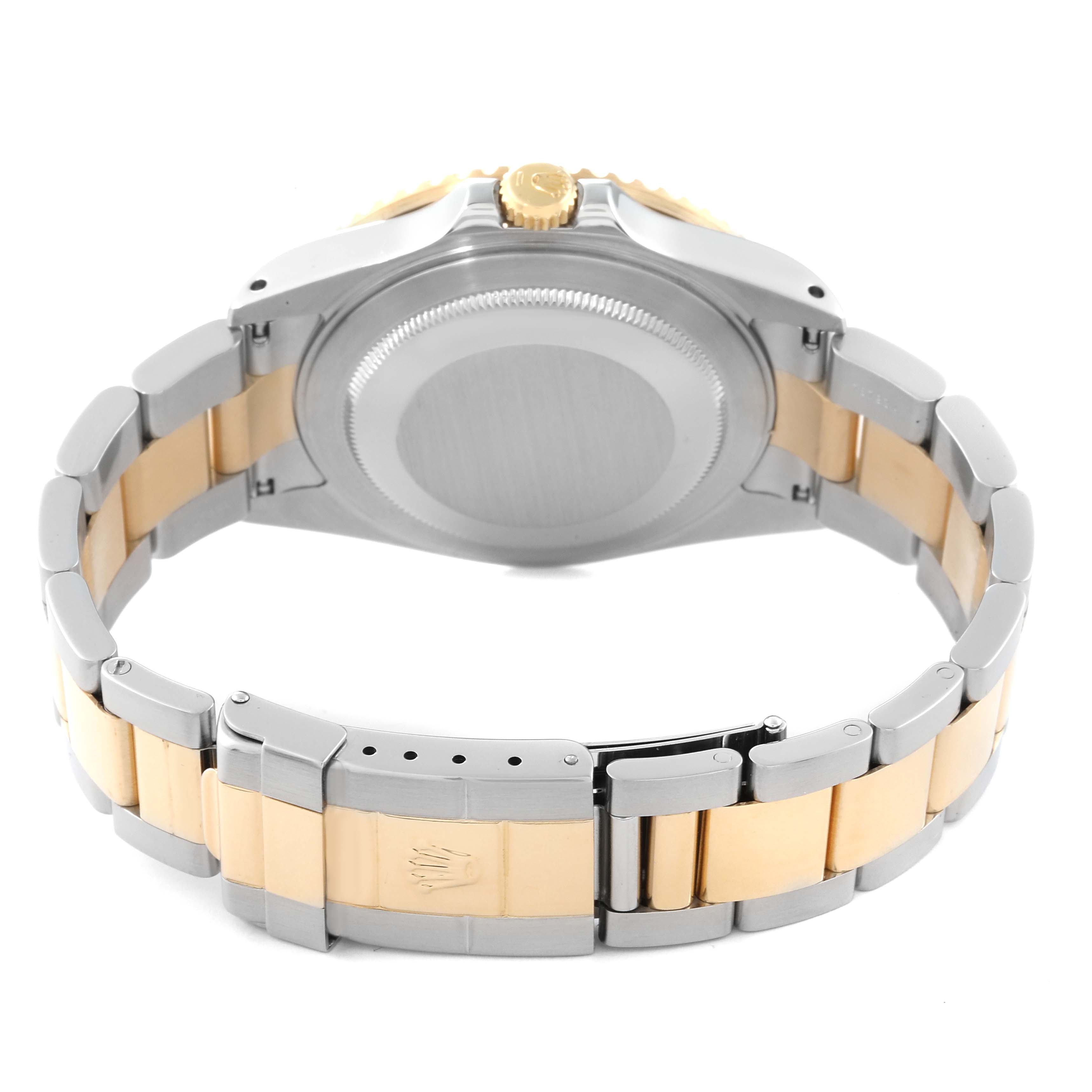 The image shows the back of a Rolex GMT-Master 16713 Men's Steel and Gold (two tone) Black Dial 16713 Men's Steel and Gold (two tone) Black Dial watch and its two-tone bracelet with the clasp partially open.