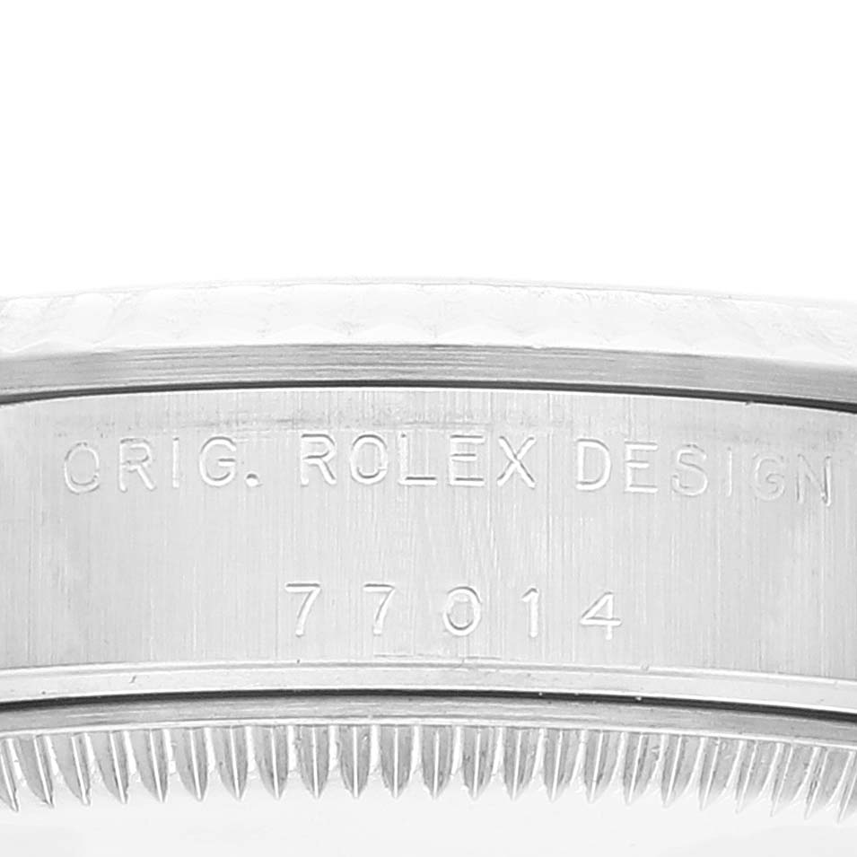 The image shows a close-up of the side of a Rolex Mid-Size 77014 Women
s Stainless Steel Pink Dial 77014 Women
s Stainless Steel Pink Dial model watch case with the engraving "ORIG. ROLEX DESIGN 77014."