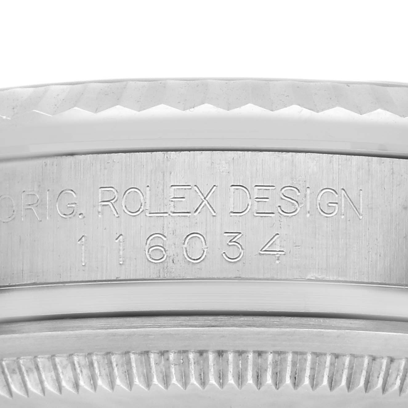 This image shows the side engraving on the case of a Rolex Oyster Perpetual 116034 Men's Steel and Gold (two tone) Silver Dial 116034 Men's Steel and Gold (two tone) Silver Dial watch, indicating the model and serial number.