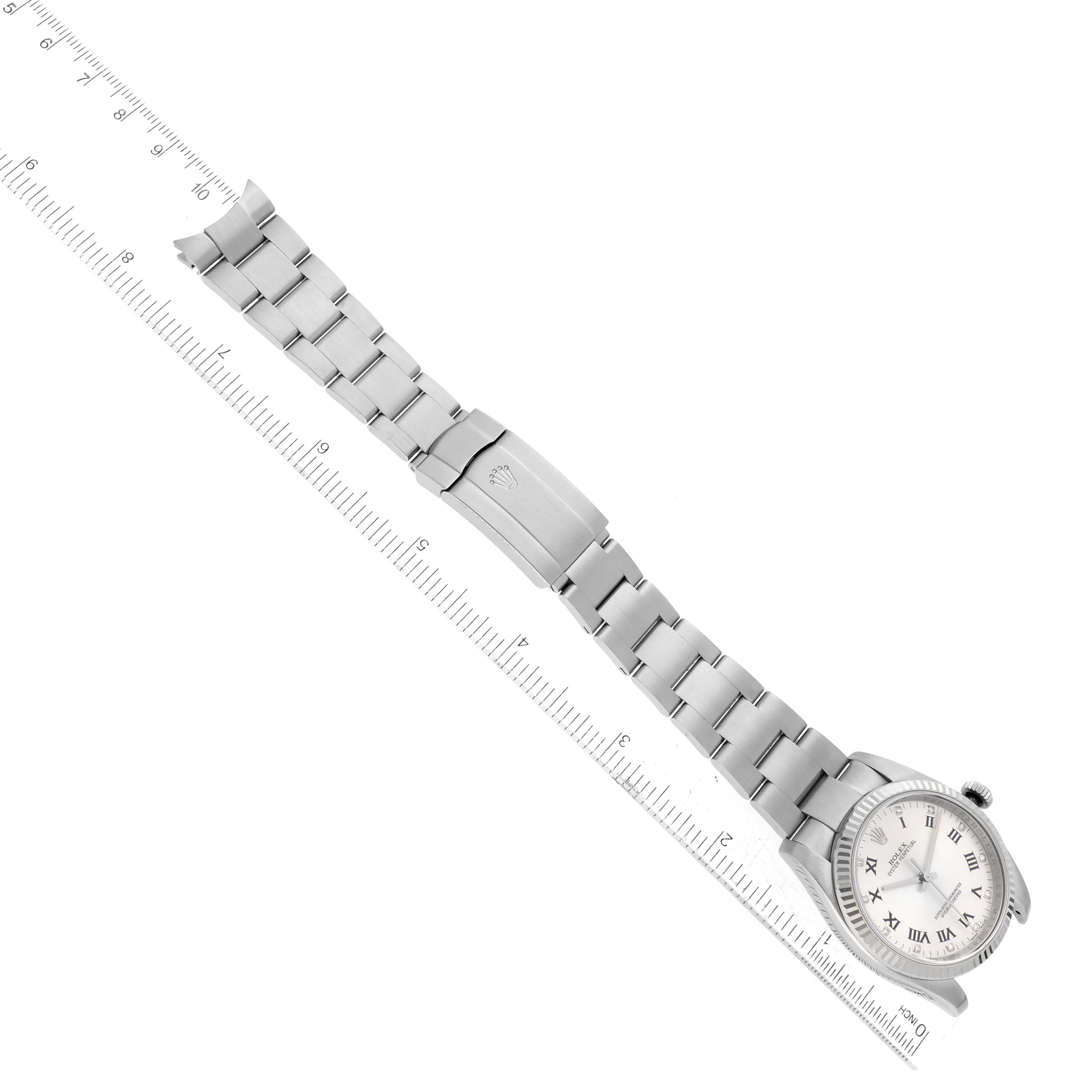 The image shows a top-down view of a Rolex Oyster Perpetual 116034 Men's Steel and Gold (two tone) Silver Dial 116034 Men's Steel and Gold (two tone) Silver Dial watch, displaying the face, band, and clasp set against a ruler for scale.