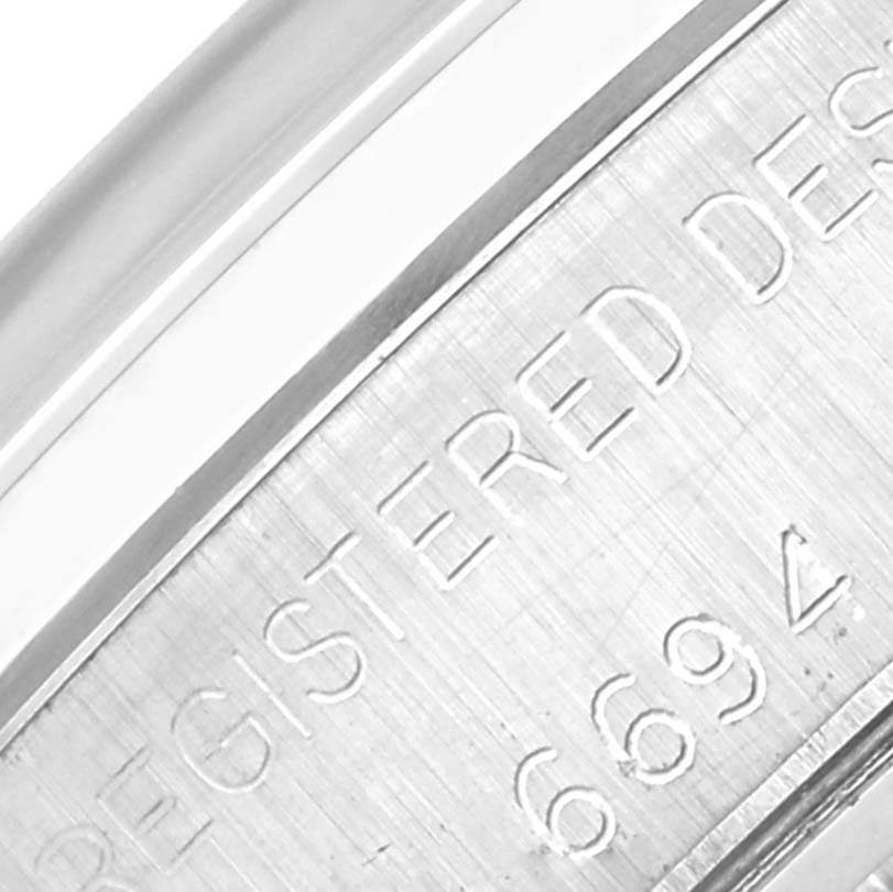 The image shows a close-up of the case side of the Rolex Vintage Collection 6694 Men's Stainless Steel Silver Dial 6694 Men's Stainless Steel Silver Dial model, highlighting engraved identification markings.