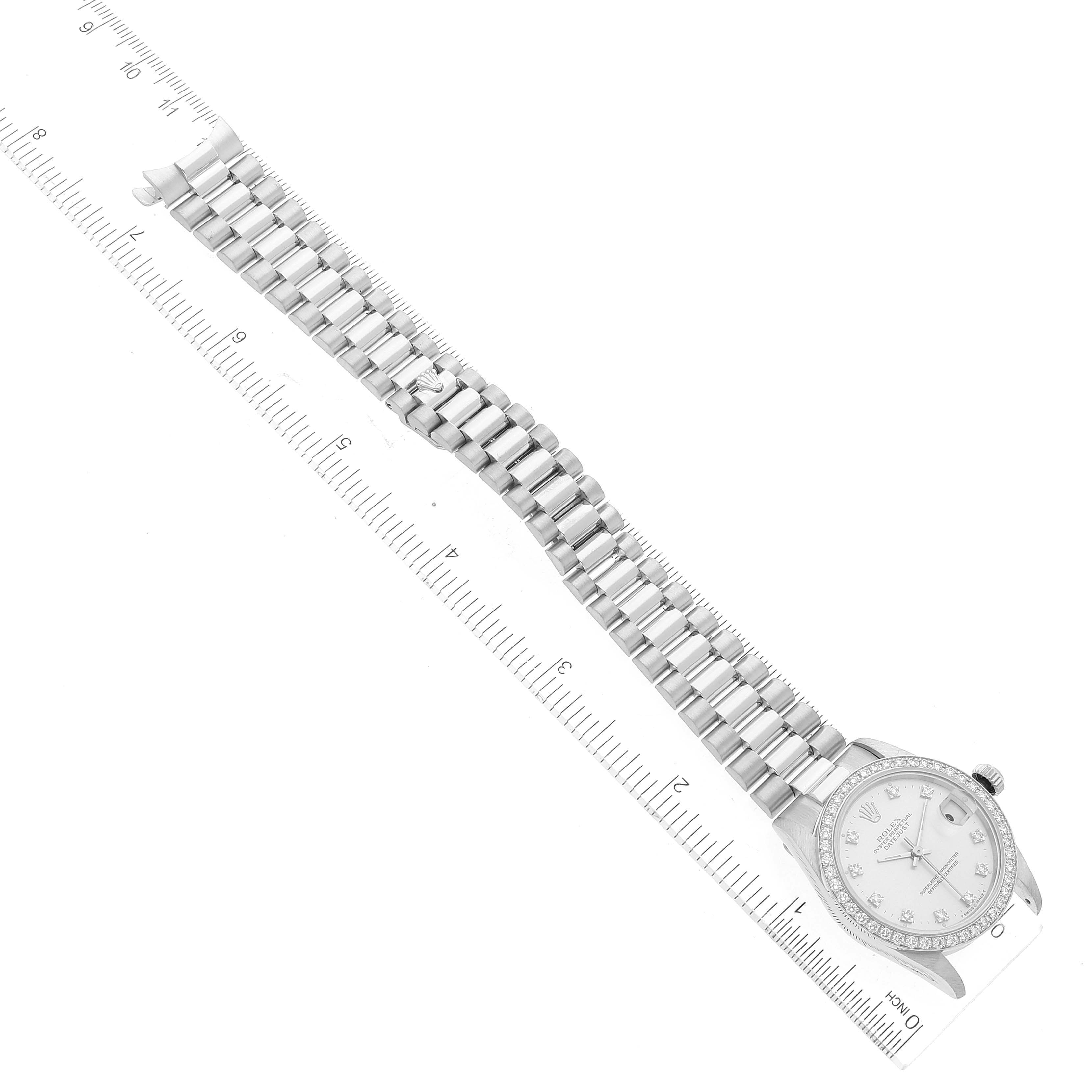 The image shows a Rolex President 68286 Women's Platinum Silver Dial 68286 Women's Platinum Silver Dial model watch lying flat, with its band fully extended along a ruler.