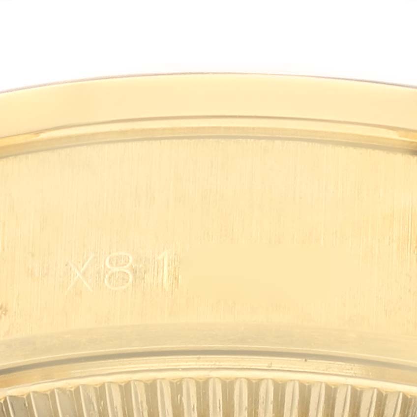 The image shows a close-up of the edge and part of the casing of a Rolex President 69068 Women's Yellow Gold Champagne Dial 69068 Women's Yellow Gold Champagne Dial model, highlighting the serial number and ridged design.