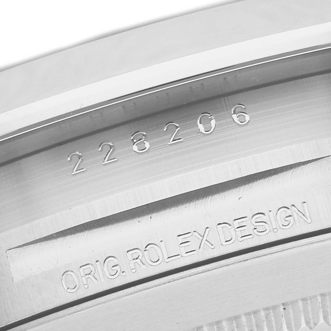 This close-up image of a Rolex President 228206 Men's Platinum Blue Dial 228206 Men's Platinum Blue Dial model shows the serial number and "ORIG. ROLEX DESIGN" engraving on its inner case back.