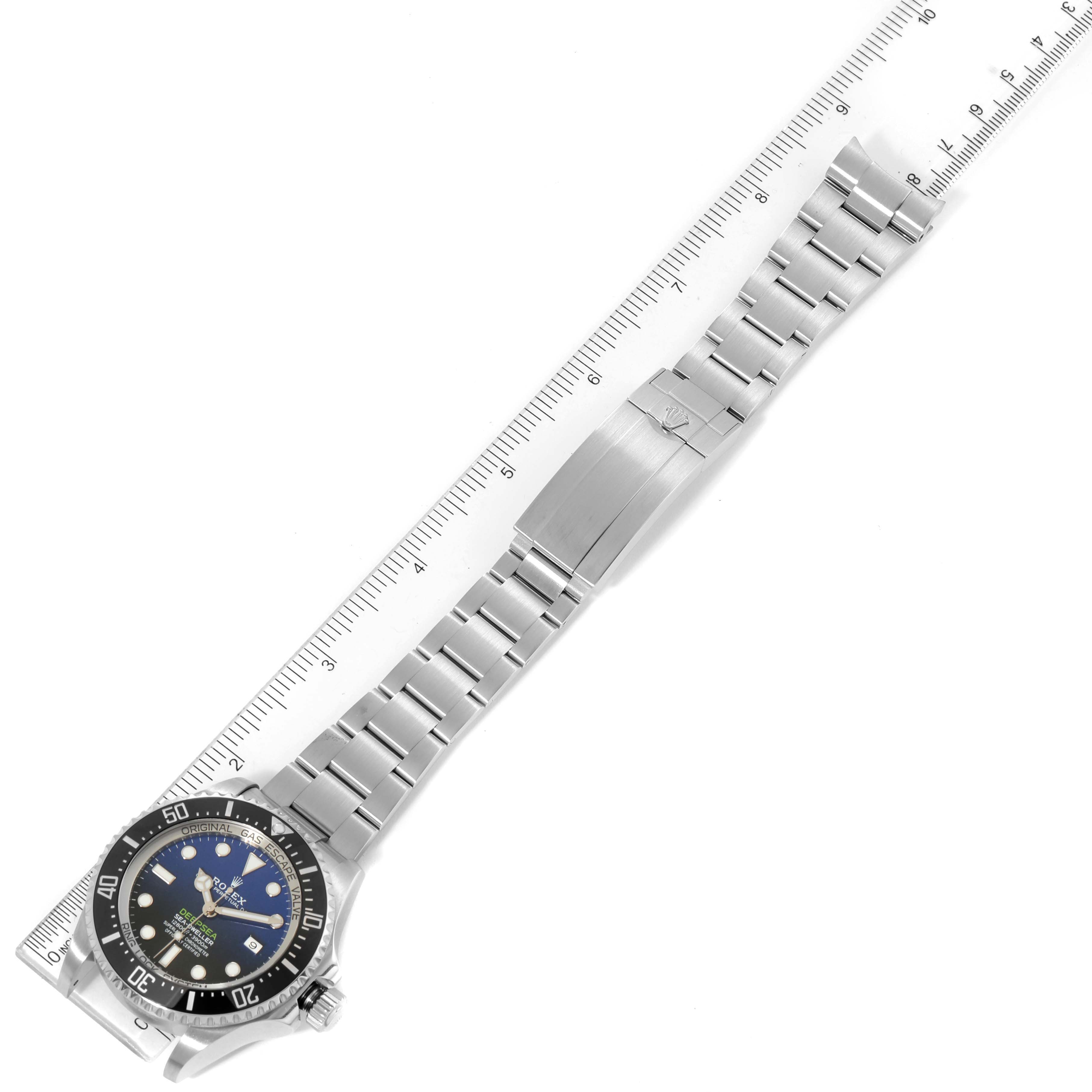This image shows a Rolex Sea-Dweller 126660 Men's Stainless Steel Blue Dial 126660 Men's Stainless Steel Blue Dial watch laid flat next to a ruler, highlighting its bracelet and clasp.