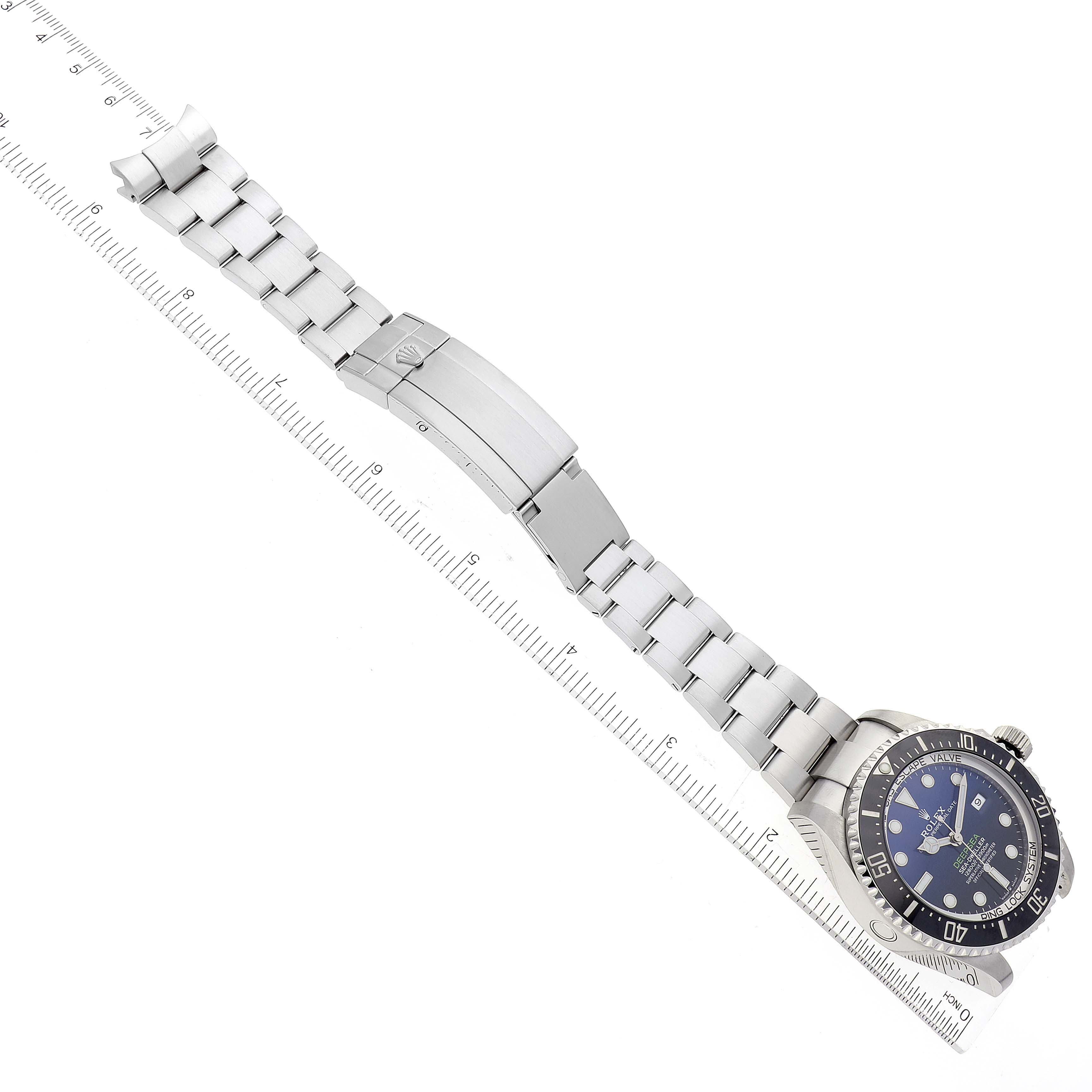 The image shows a Rolex Sea-Dweller 126660 Men's Stainless Steel Blue Dial 126660 Men's Stainless Steel Blue Dial watch laid flat with the face, bezel, and bracelet parts visible alongside a measurement ruler.