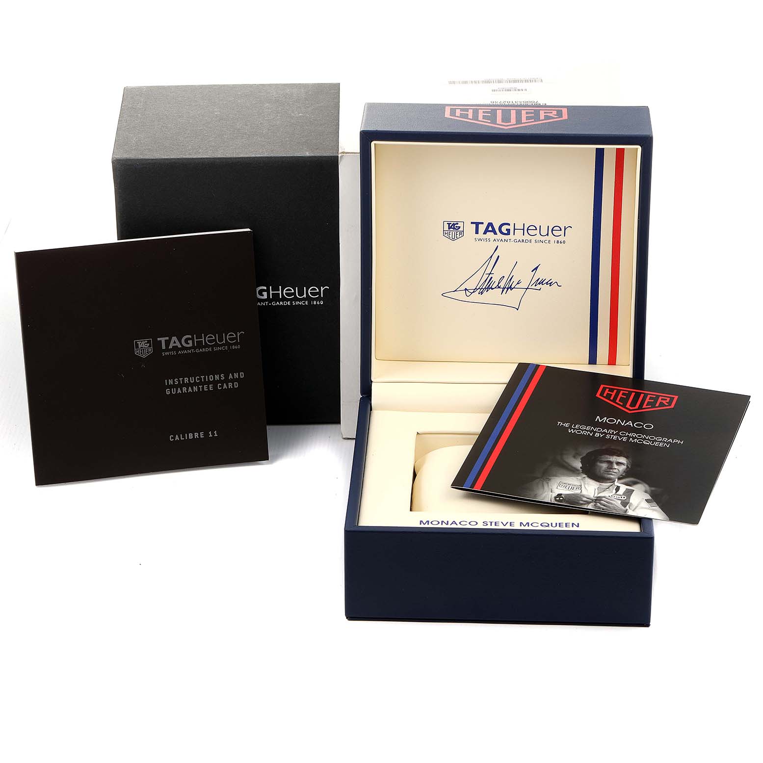 The image shows the packaging and accessories of the Tag Heuer Monaco CAW211P Men's Stainless Steel Blue Dial CAW211P Men's Stainless Steel Blue Dial watch, including the box, instruction manual, and booklet.