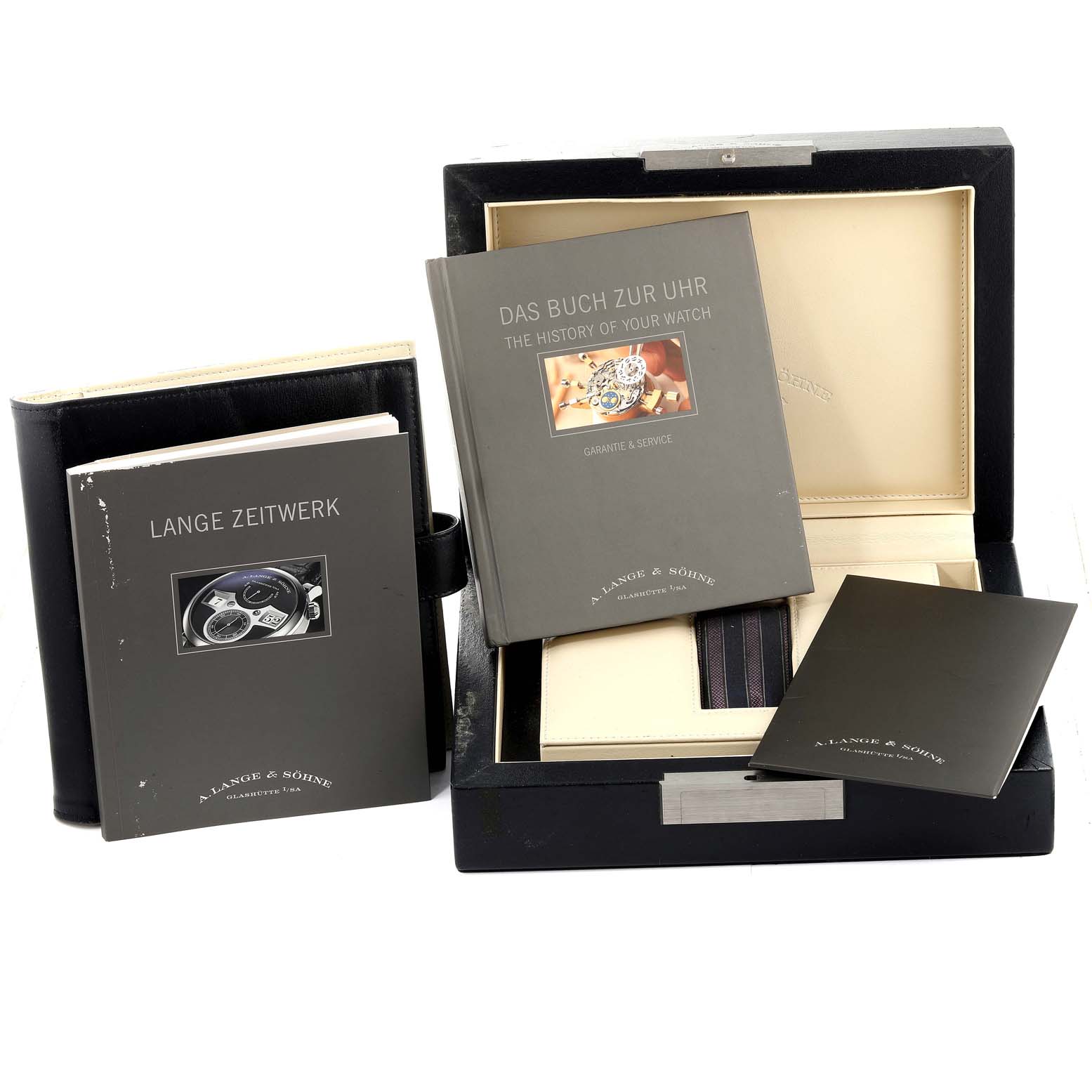 The image shows the packaging and documentation for the Zeitwerk model by A. Lange & Sohne, including manuals and a display box.