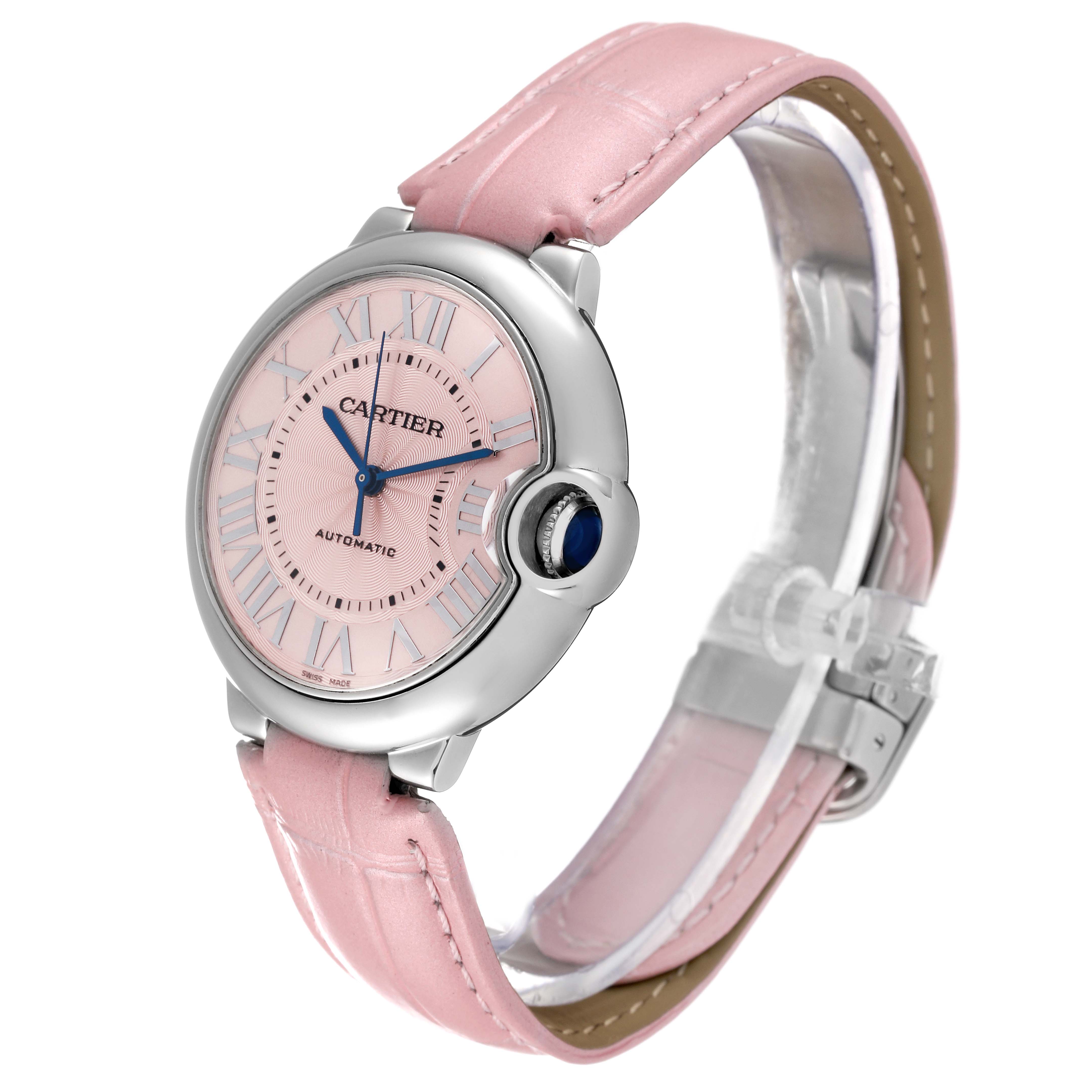 The image shows a Cartier Ballon Bleu WSBB0007 Women
s Stainless Steel Pink Dial WSBB0007 Women
s Stainless Steel Pink Dial watch at a three-quarter angle, displaying its pink dial, blue hands, crown with a blue cabochon, and pink leather strap.