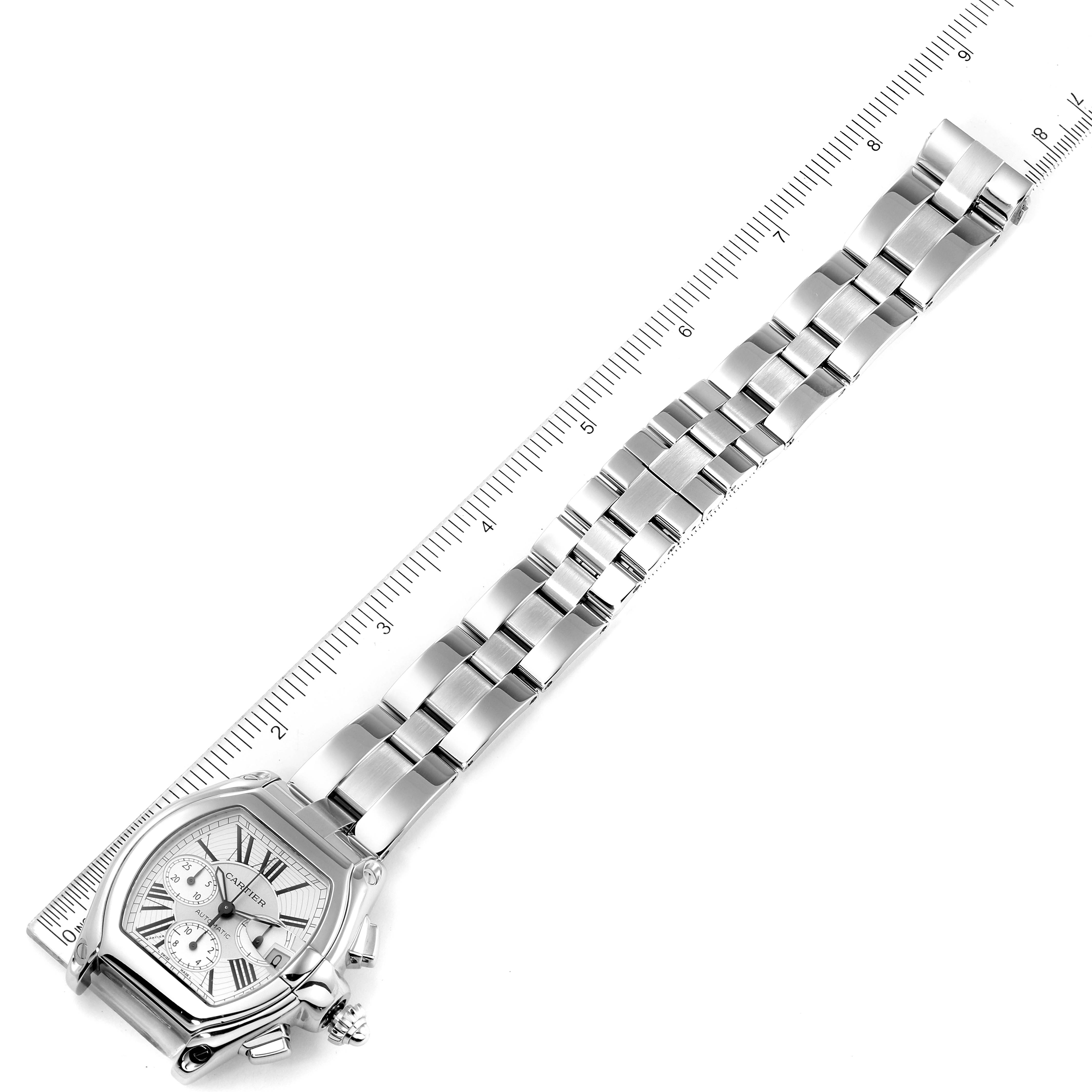 The image shows the Cartier Roadster W62019X6 Men
s Stainless Steel Silver Dial W62019X6 Men
s Stainless Steel Silver Dial watch laid flat with the face, bezel, and bracelet fully visible next to a ruler.