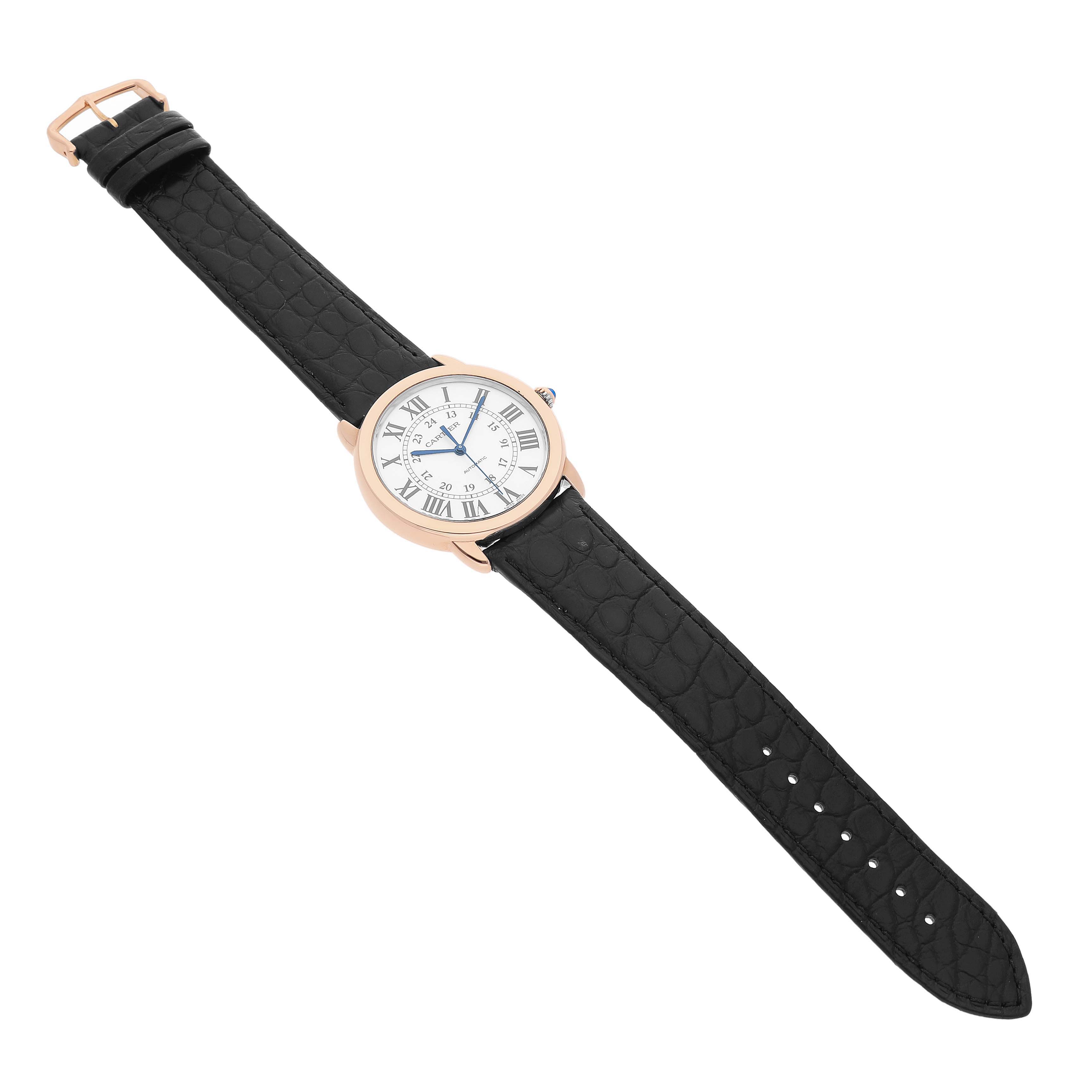 The Cartier Ronde W2RN0008 Men's Rose Gold Silver Dial watch is shown from an overhead angle, displaying its black strap and round face with Roman numerals.