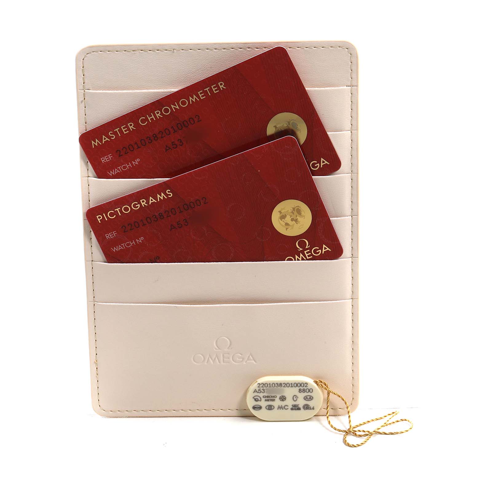 The image shows an Omega Seamaster 220.10.38.20.10.002 Men's Stainless Steel Green Dial accessories set with two red cards in a holder, and a tag displaying model details.