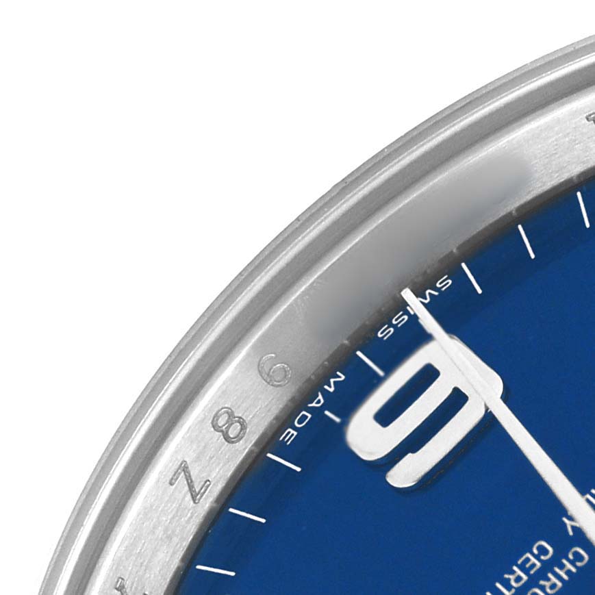The image shows a close-up of the Rolex Air-King 114200 Men's Stainless Steel Blue Dial's bezel, dial, and minute hand at an angle highlighting the 9 o'clock marker.