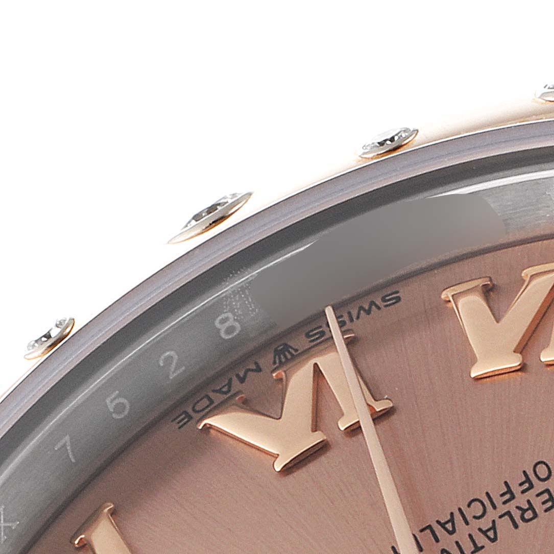 The image displays a close-up of the Rolex Mid-Size 278341 Women's Steel and Gold (two tone) Pink Dial 278341 Women's Steel and Gold (two tone) Pink Dial model watch dial, showcasing the hour markers, partial minute markers, and the bezel with embedded gemstones.