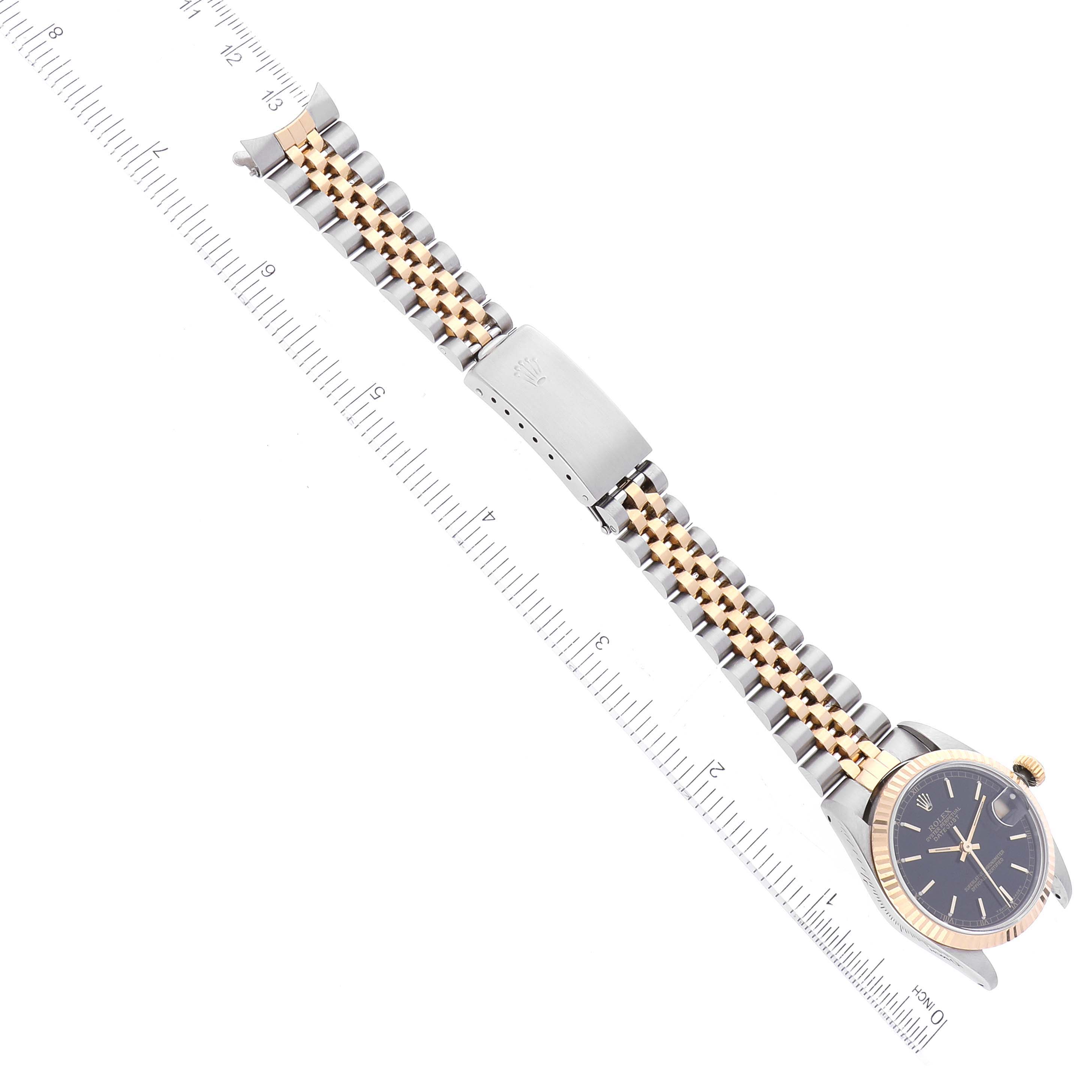 This image shows a top-down view of a Rolex Mid-Size 68273 Women's Steel and Gold (two tone) Black Dial 68273 Women's Steel and Gold (two tone) Black Dial watch, highlighting the face, bezel, and bracelet with a ruler for scale.