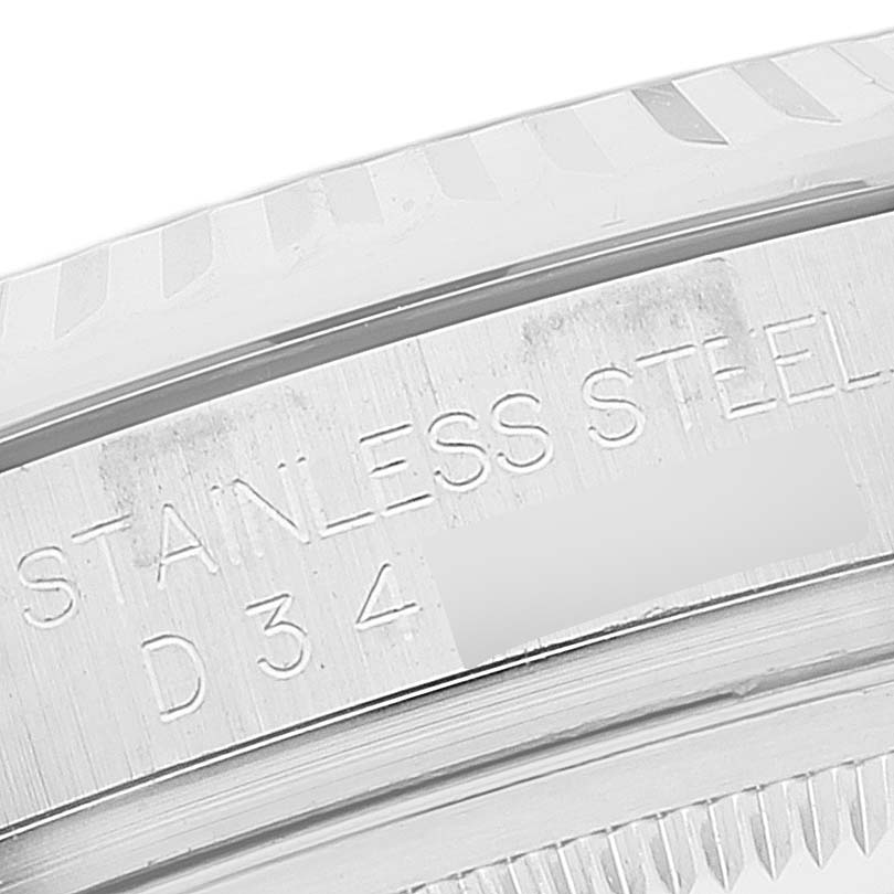 The image shows a close-up of the side of the stainless steel bezel and a part of the case back of a Rolex Datejust 116234 Men's Stainless Steel Silver Dial 116234 Men's Stainless Steel Silver Dial watch.