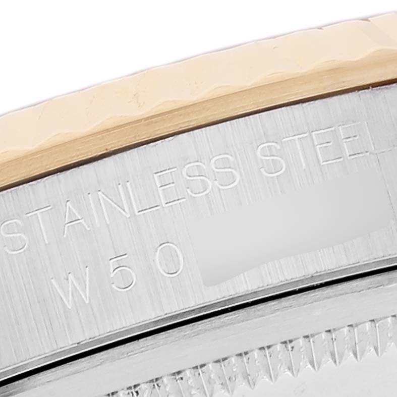 The image shows a close-up of the case back engraving and the edge of the fluted bezel of a Rolex Datejust 16233 Men's Steel and Gold (two tone) White Dial 16233 Men's Steel and Gold (two tone) White Dial watch.