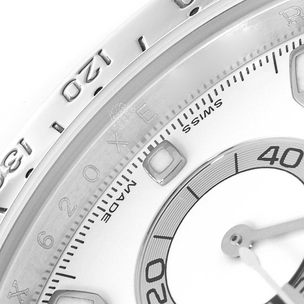 The image shows a close-up of the dial and bezel of a Rolex Daytona 116520 Men's Stainless Steel White Dial 116520 Men's Stainless Steel White Dial watch, highlighting the numbers and part of the sub-dial.