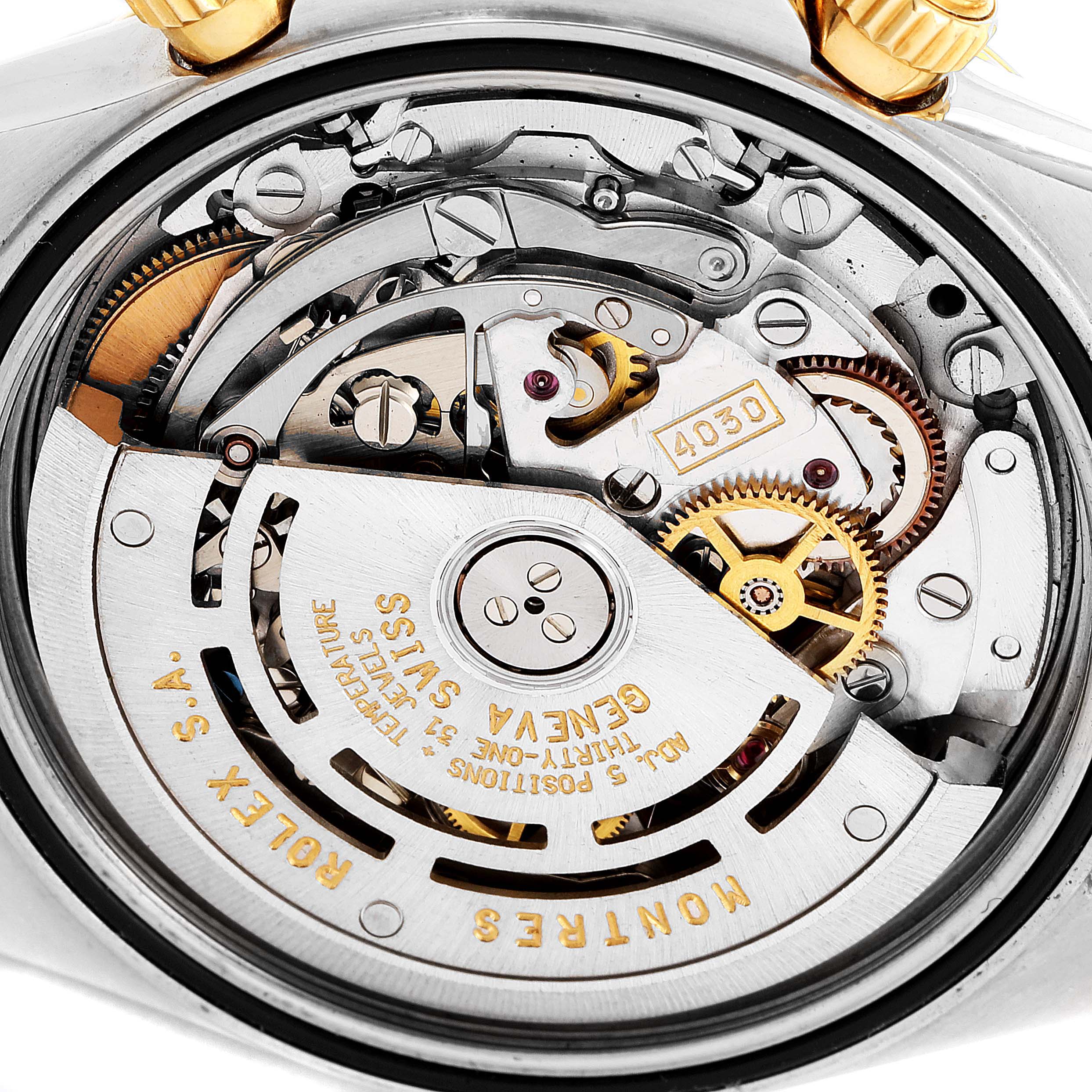 This image shows the internal mechanism of a Rolex Daytona 16523 Men
s Steel and Gold (two tone) Black Dial 16523 Men
s Steel and Gold (two tone) Black Dial watch from a close-up angle, highlighting the gears and engravings.
