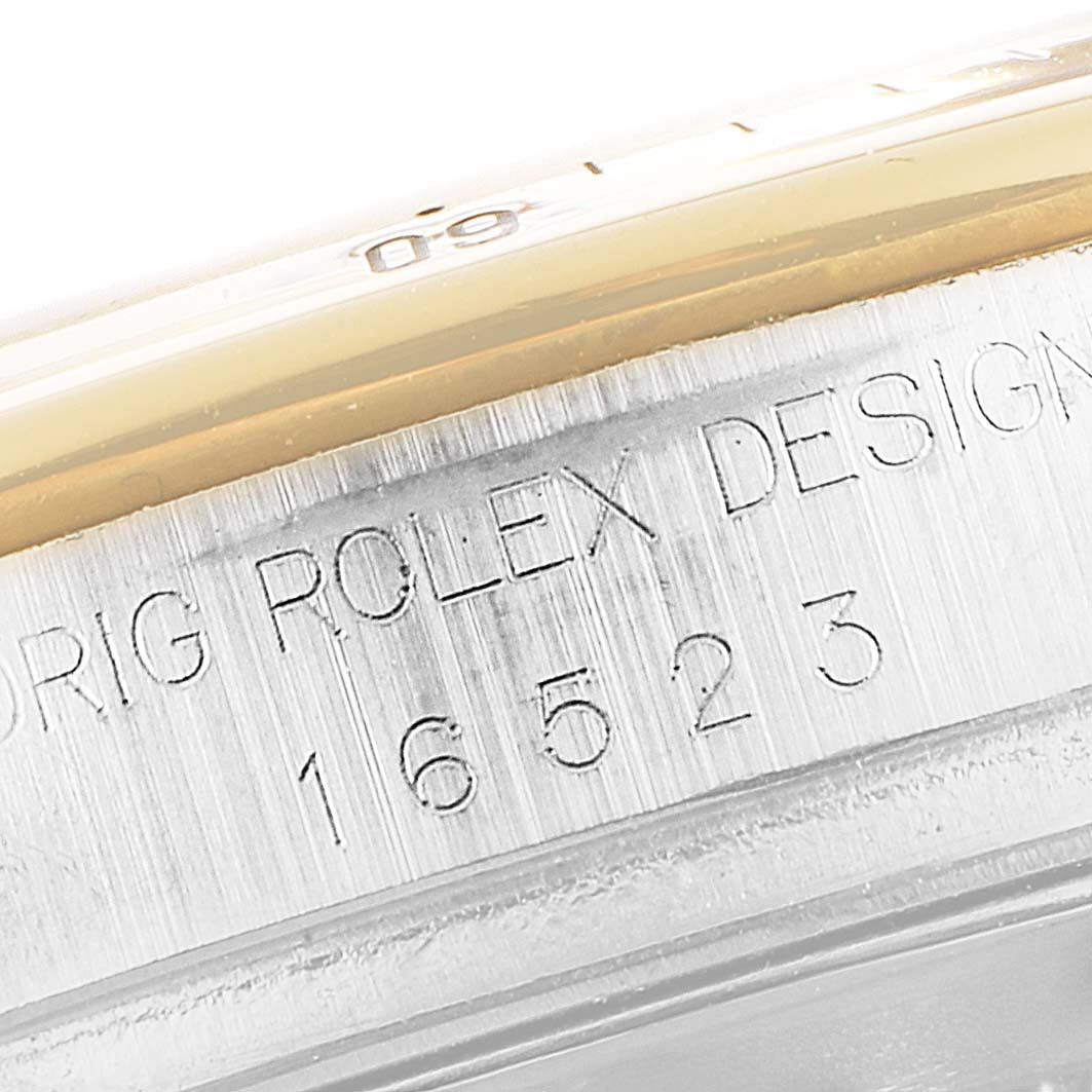 The image shows a close-up of the model number and engraving on the side of the Rolex Daytona 16523 Men
s Steel and Gold (two tone) Black Dial 16523 Men
s Steel and Gold (two tone) Black Dial watch case.
