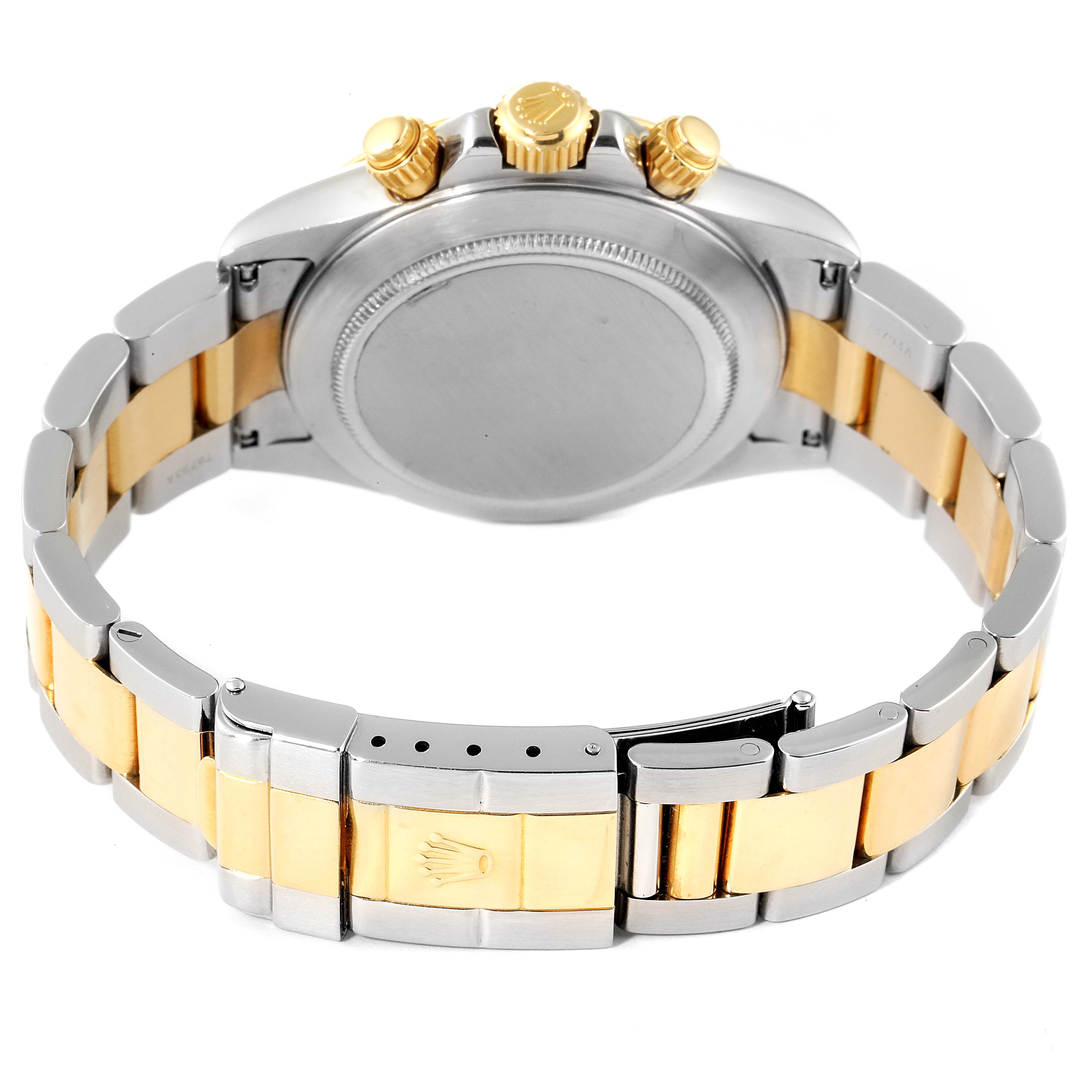 The image shows the back view of a Rolex Daytona 16523 Men
s Steel and Gold (two tone) Black Dial 16523 Men
s Steel and Gold (two tone) Black Dial watch, highlighting the two-tone bracelet and the crown on the clasp.