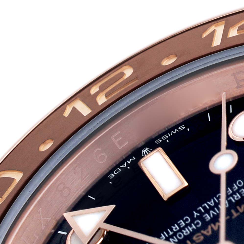 The image shows a close-up of the bezel, dial, and part of the hands of a Rolex GMT-Master 126715 Men's Rose Gold Black Dial watch.