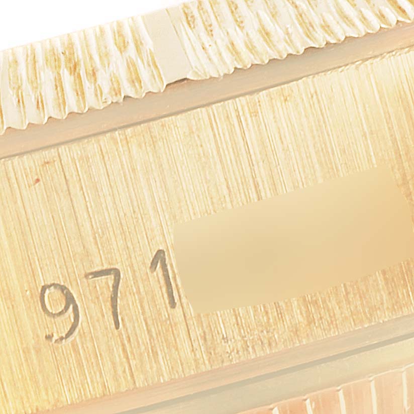 This image shows a close-up angle of the serial number and fluted bezel of a Rolex President 69278 Women's Yellow Gold Beige Dial 69278 Women's Yellow Gold Beige Dial model watch.
