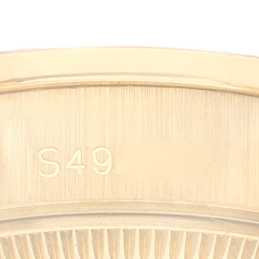 This image shows a close-up of the side of a Rolex President 69158 Women
s Yellow Gold Champagne Dial 69158 Women
s Yellow Gold Champagne Dial model watch, highlighting part of the serial number engraving.