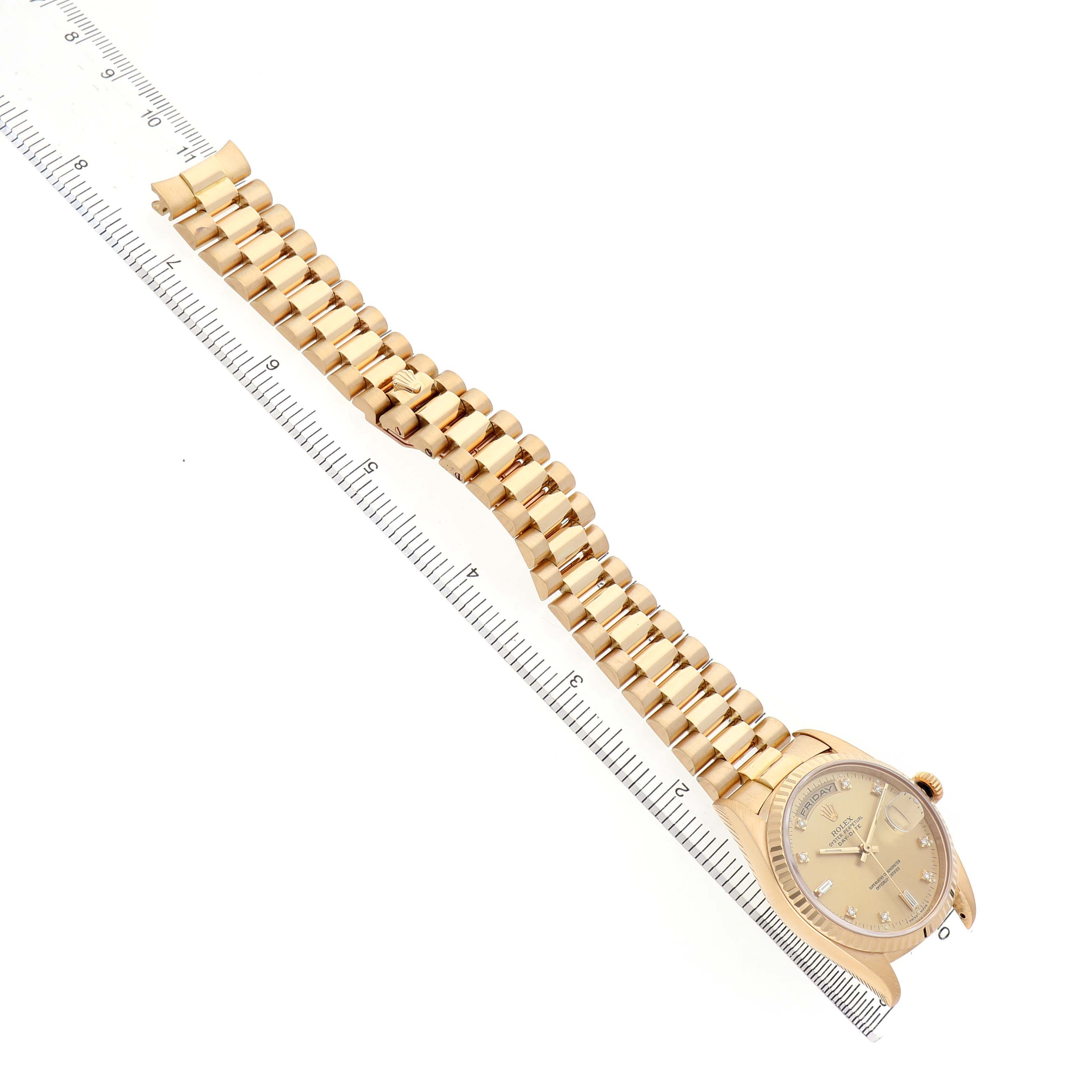 The Rolex President 18238 Men's Yellow Gold Champagne Dial watch is shown at an oblique angle, displaying the watch face and full gold bracelet laid against a ruler.