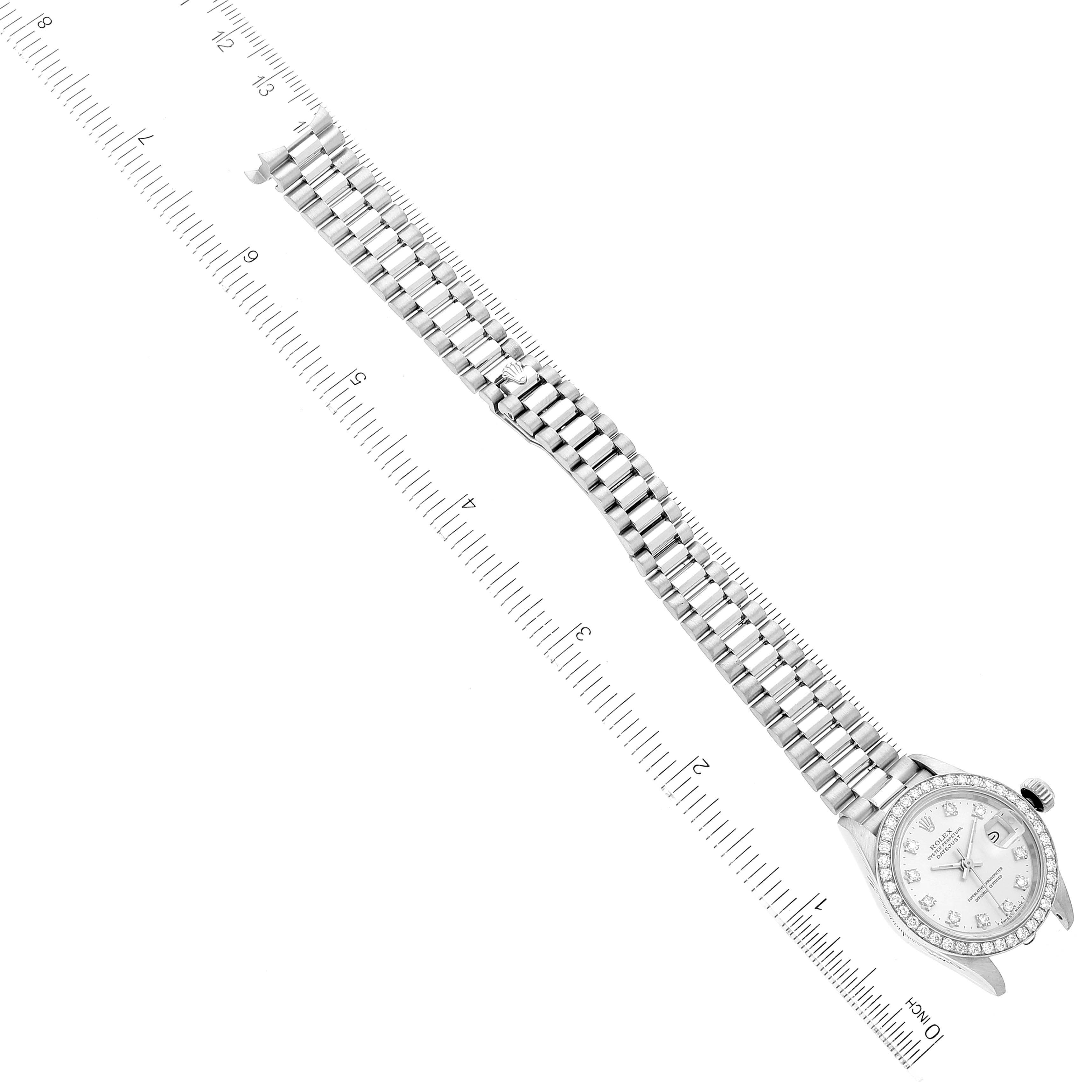 The image shows a top-down view of a Rolex President 69136 Women's Platinum Silver Dial 69136 Women's Platinum Silver Dial model watch with its bracelet aligned along a ruler.