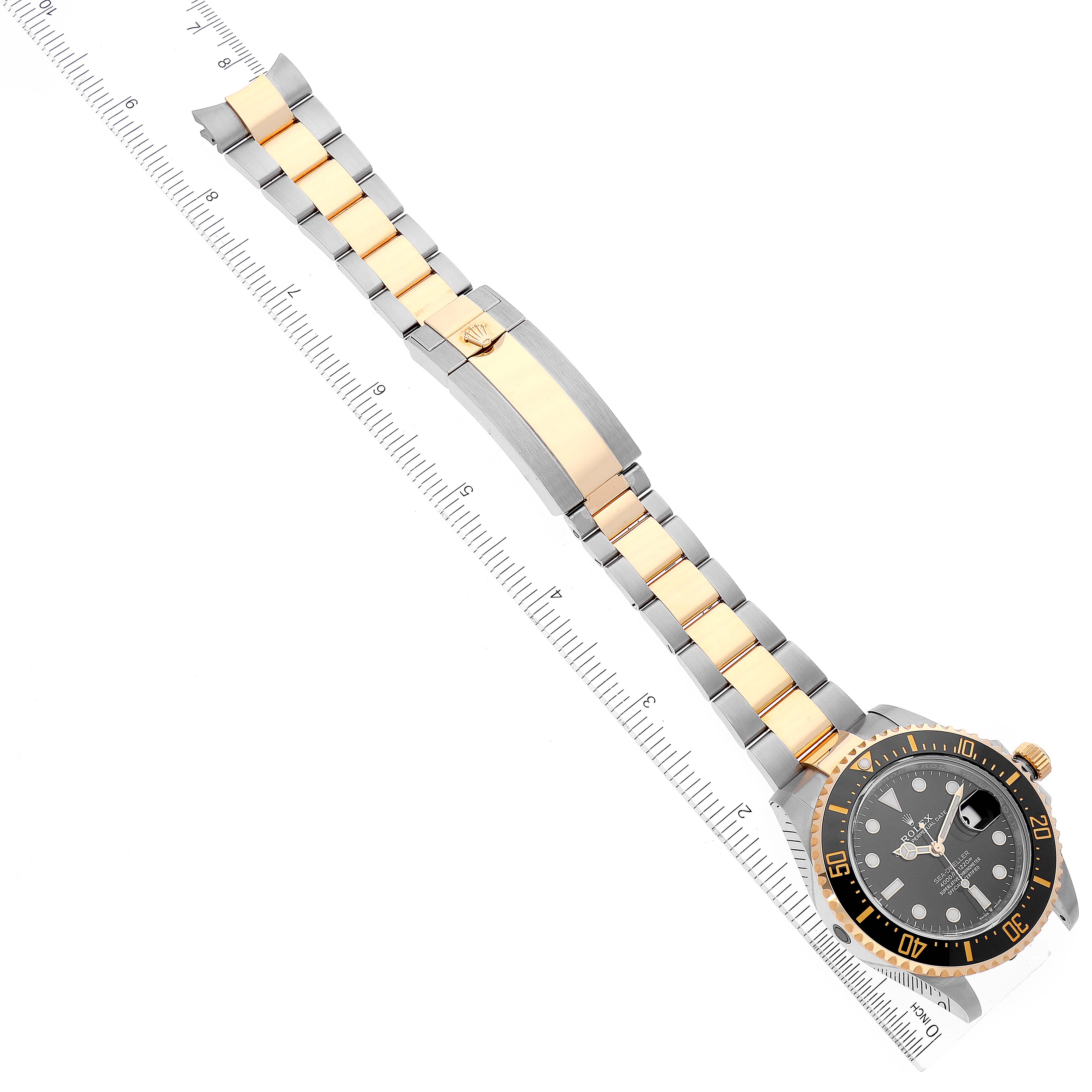 This image shows a Rolex Sea-Dweller 126603 Men's Steel and Gold (two tone) Black Dial 126603 Men's Steel and Gold (two tone) Black Dial watch laid flat with its entire band and dial visible, alongside a ruler for scale.