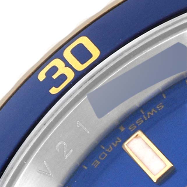 The image shows a close-up of the blue and gold bezel and part of the dial of a Rolex Submariner 16613 Men's Steel and Gold (two tone) Blue Dial 16613 Men's Steel and Gold (two tone) Blue Dial watch.