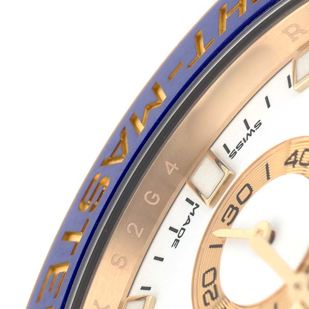 The image shows a close-up of the Rolex Yacht-Master 116688 Men's Yellow Gold White Dial's blue bezel, dial, and part of the minute hand.