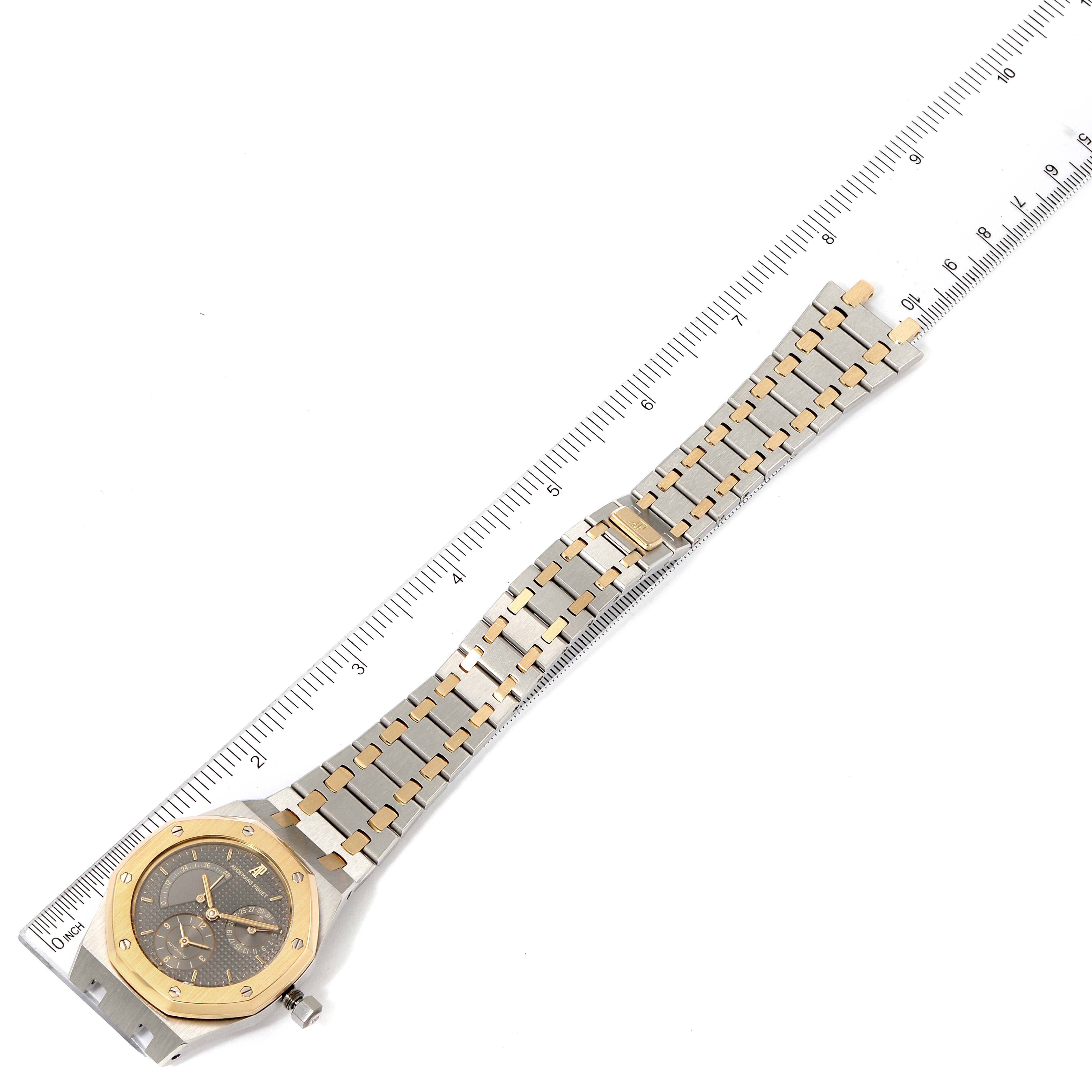 The image shows a laid flat Audemars Piguet Royal Oak 25730SA.01.078 Men
s Steel and Gold (two tone) Silver Dial 25730SA.01.078 Men
s Steel and Gold (two tone) Silver Dial watch with its bracelet aligned next to a ruler for measurement.