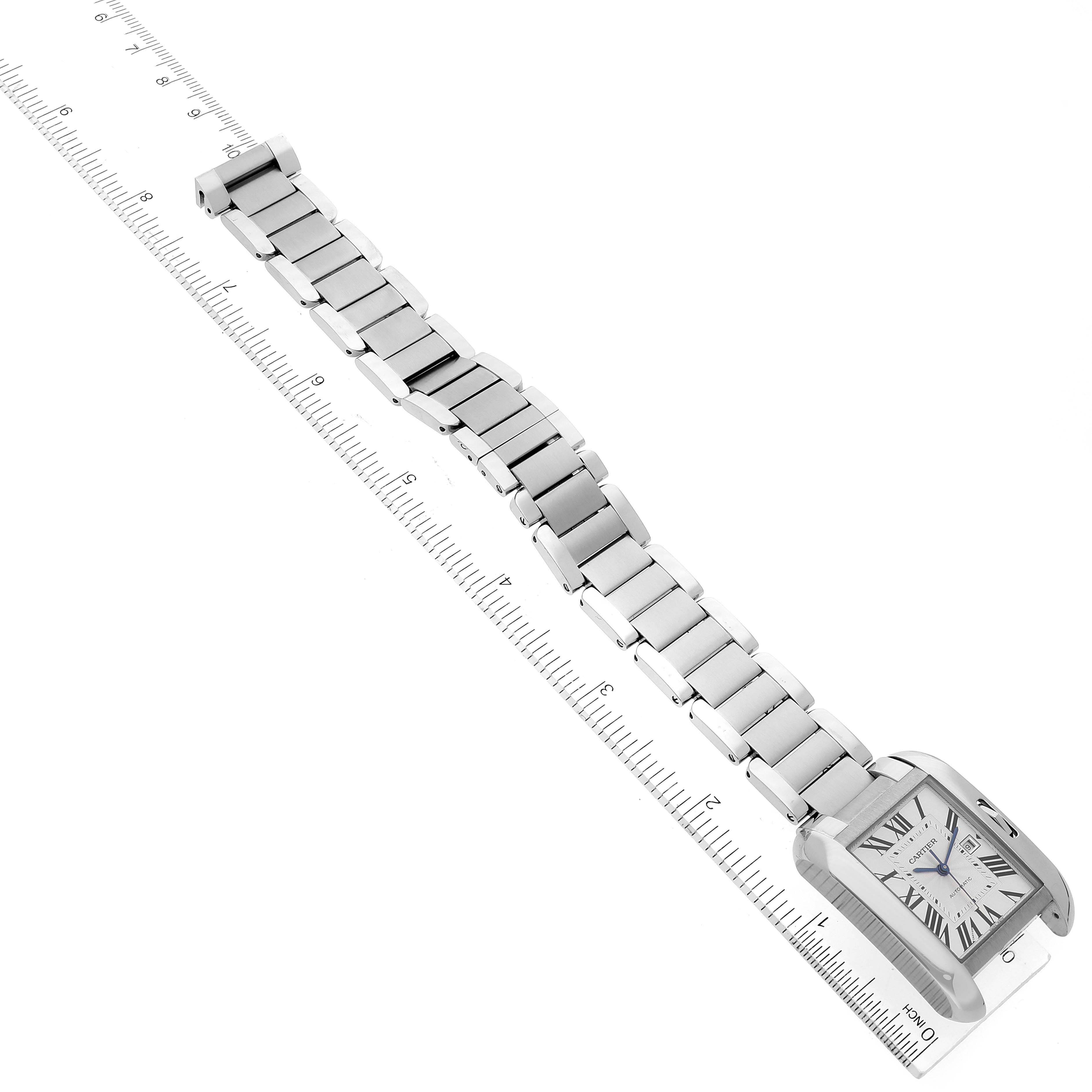 The image shows a Cartier Tank Anglaise W5310009 Men
s Stainless Steel Silver Dial W5310009 Men
s Stainless Steel Silver Dial watch laid out flat with a ruler, displaying its case, dial, and bracelet from an overhead angle.