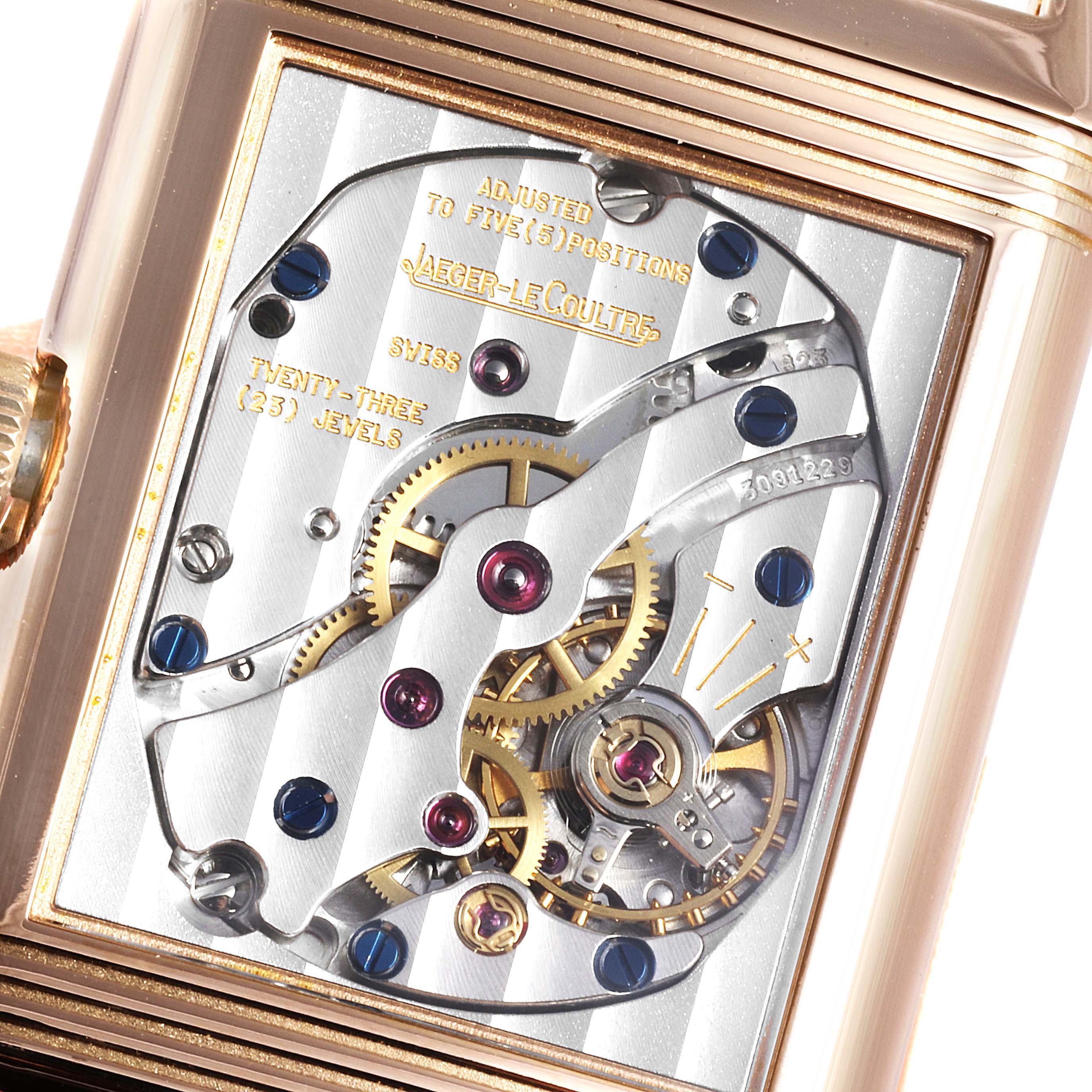 The image shows a close-up of the movement mechanism of a Jaeger-LeCoultre Reverso watch, focusing on the internal gears and jewels.
