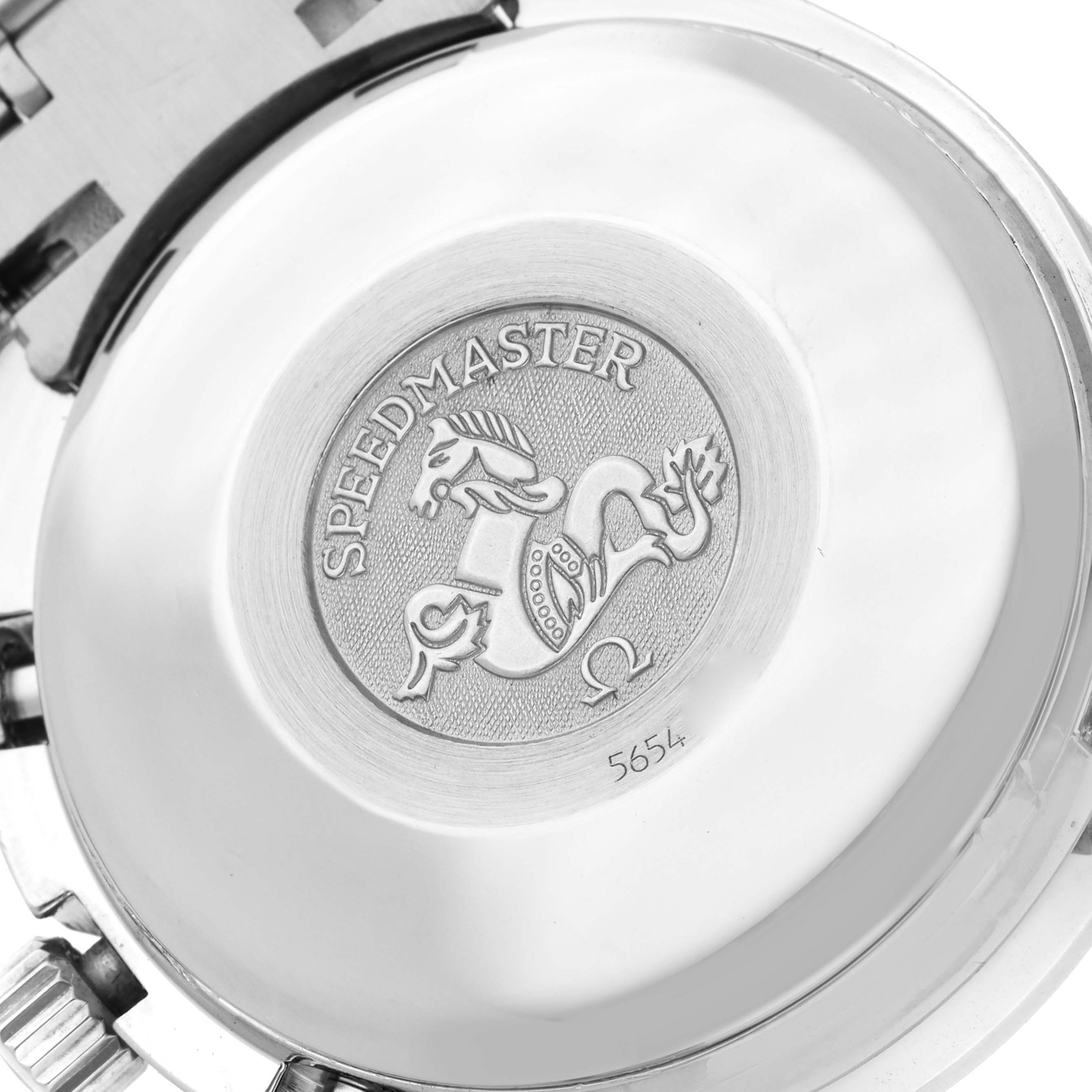 The image shows the back case of an Omega Speedmaster 3520.50.00 Men
s Stainless Steel Black Dial watch, featuring an embossed emblem and engraving details.