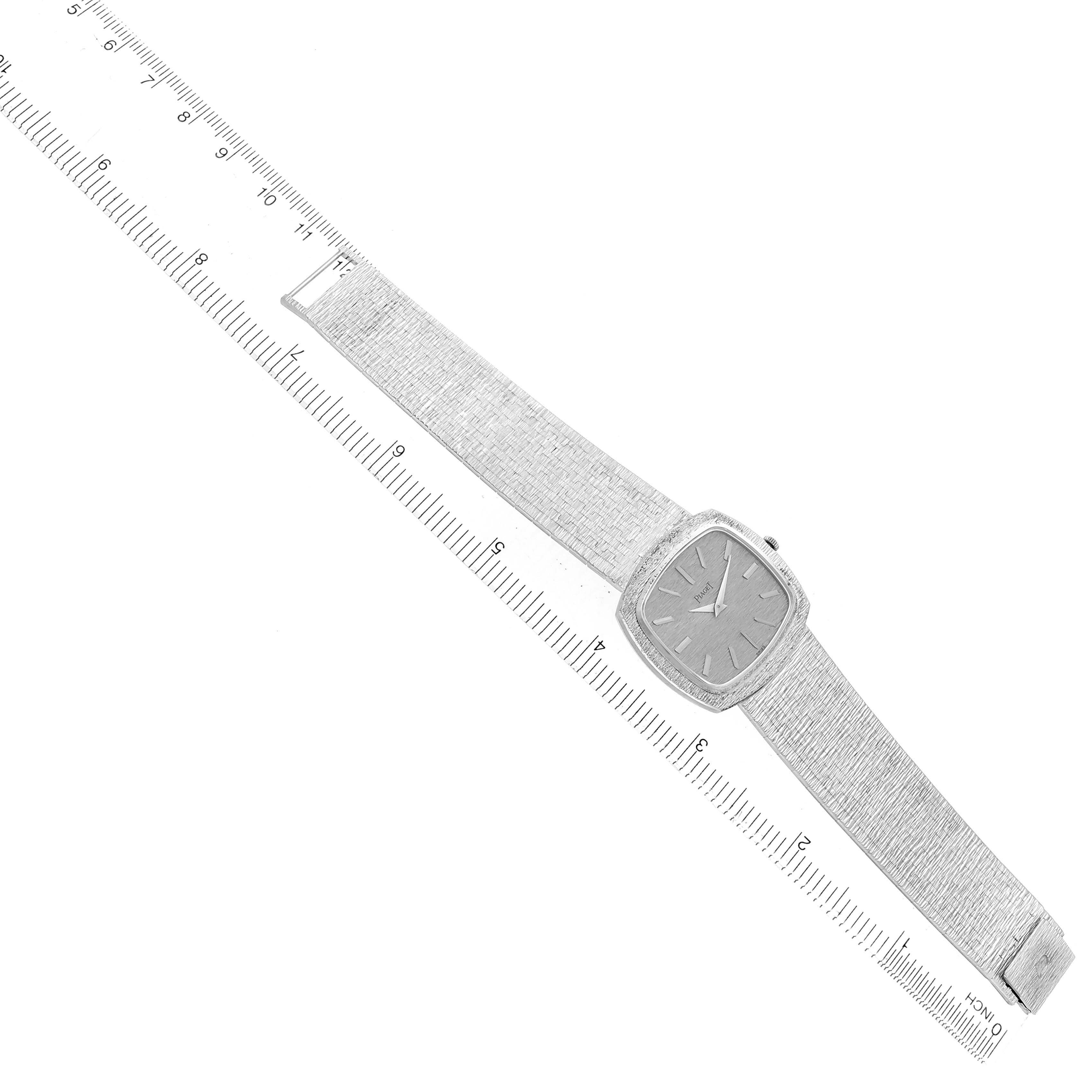 The Piaget 9431A6 Women
s White Gold Silver Dial 9431A6 watch is shown at an overhead angle, displaying the face, bezel, and textured bracelet with a ruler alongside.