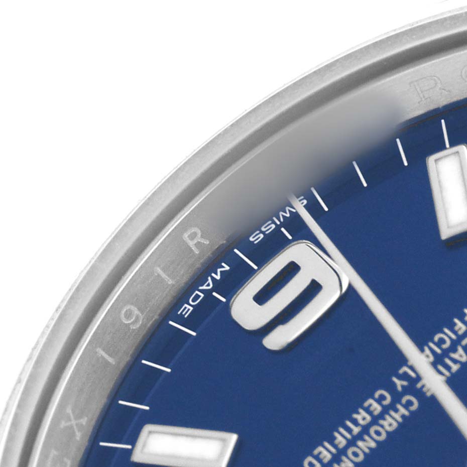 The image shows a close-up of the Rolex Air-King 114200 Men's Stainless Steel Blue Dial watch's blue dial with part of the bezel and the number 9.