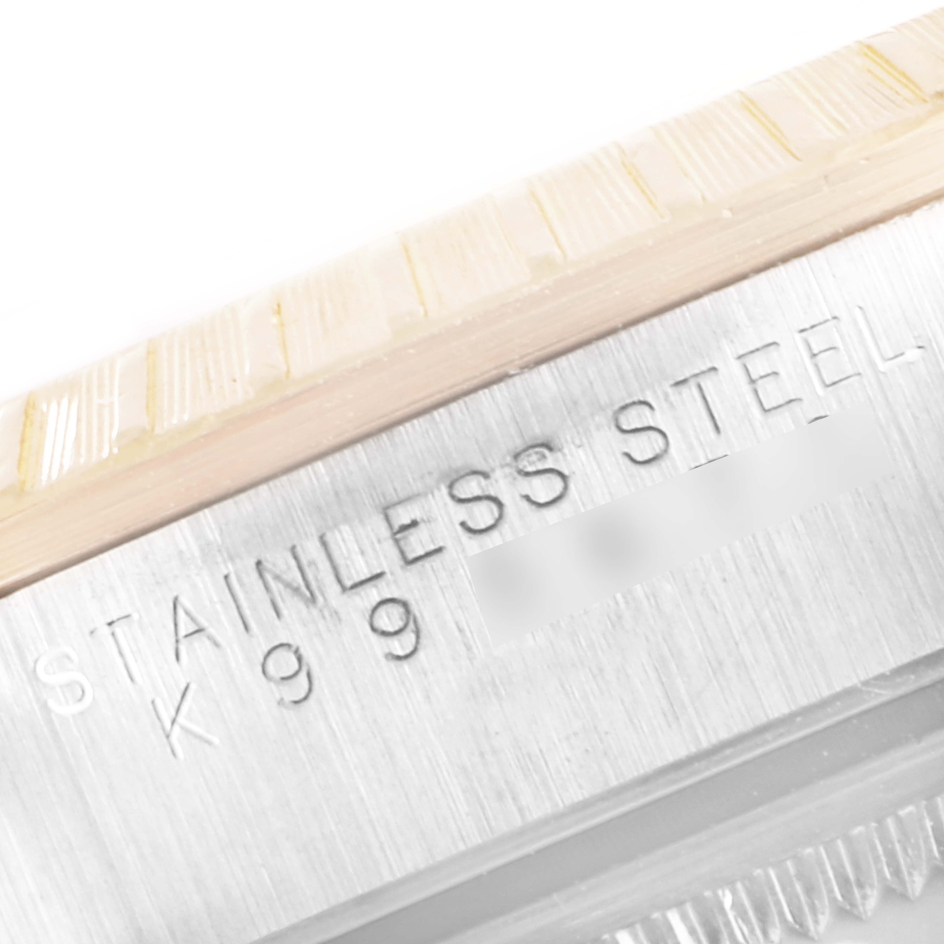 This image shows a close-up of the engraved text "STAINLESS STEEL" on a Rolex Date 15223 Men's Steel and Gold (two tone) White Dial 15223 Men's Steel and Gold (two tone) White Dial model watch case.