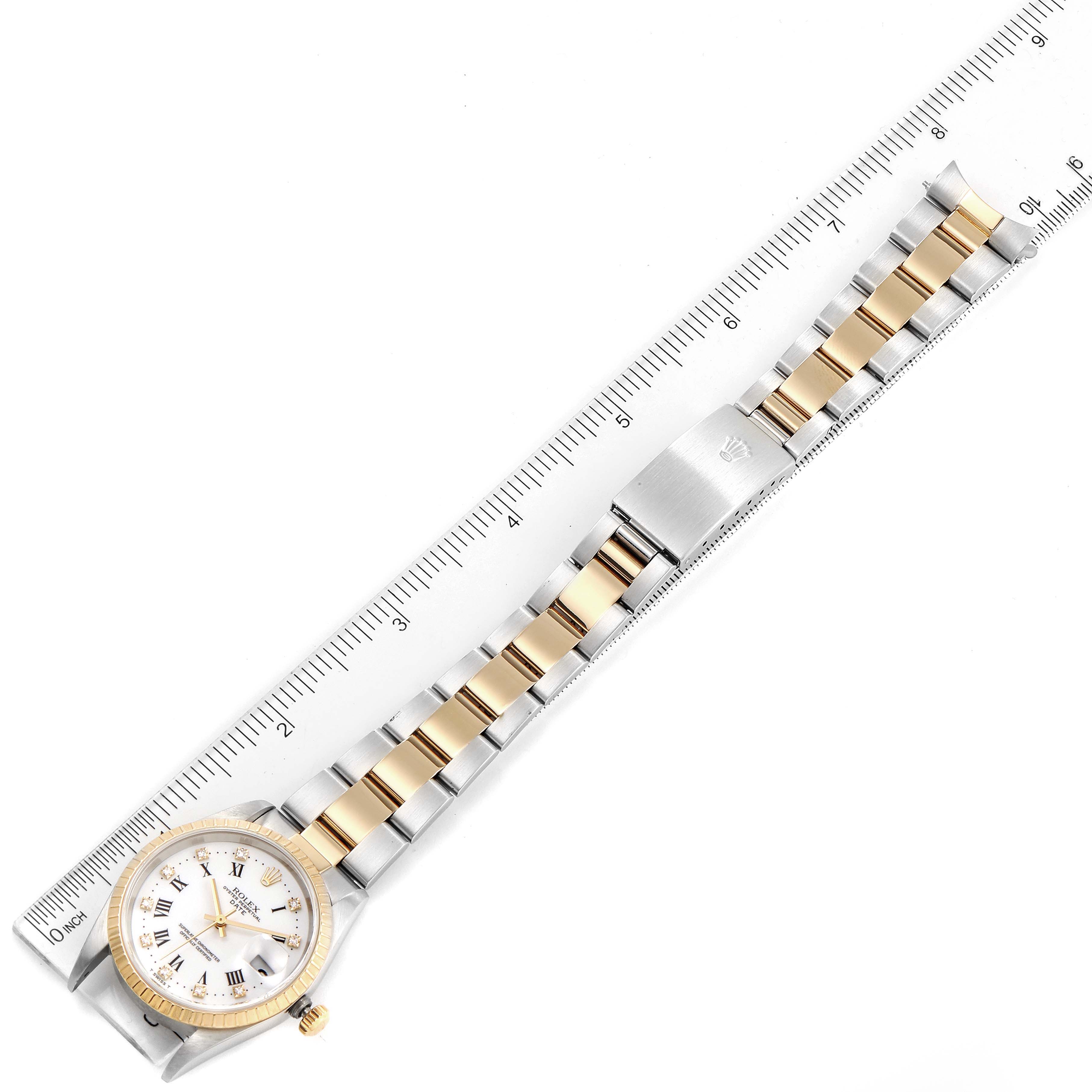 This top-down view of the Rolex Date 15223 Men's Steel and Gold (two tone) White Dial 15223 Men's Steel and Gold (two tone) White Dial model watch shows the face, bezel, and entire bracelet alongside a ruler for scale.