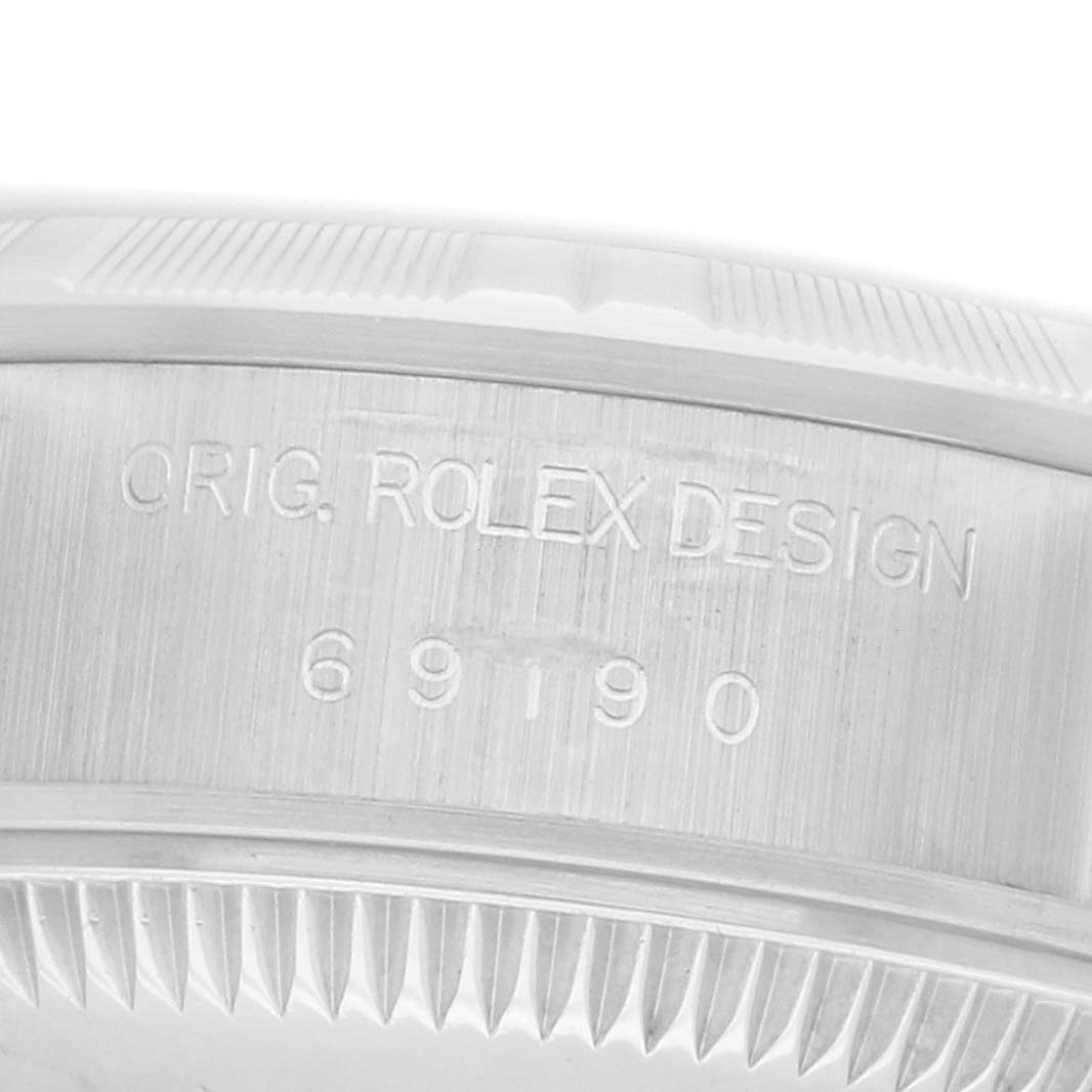 The image shows a close-up of the inner bezel of a Rolex Date 69190 Women
s Stainless Steel Silver Dial model, displaying "ORIG. ROLEX DESIGN" and a serial number.